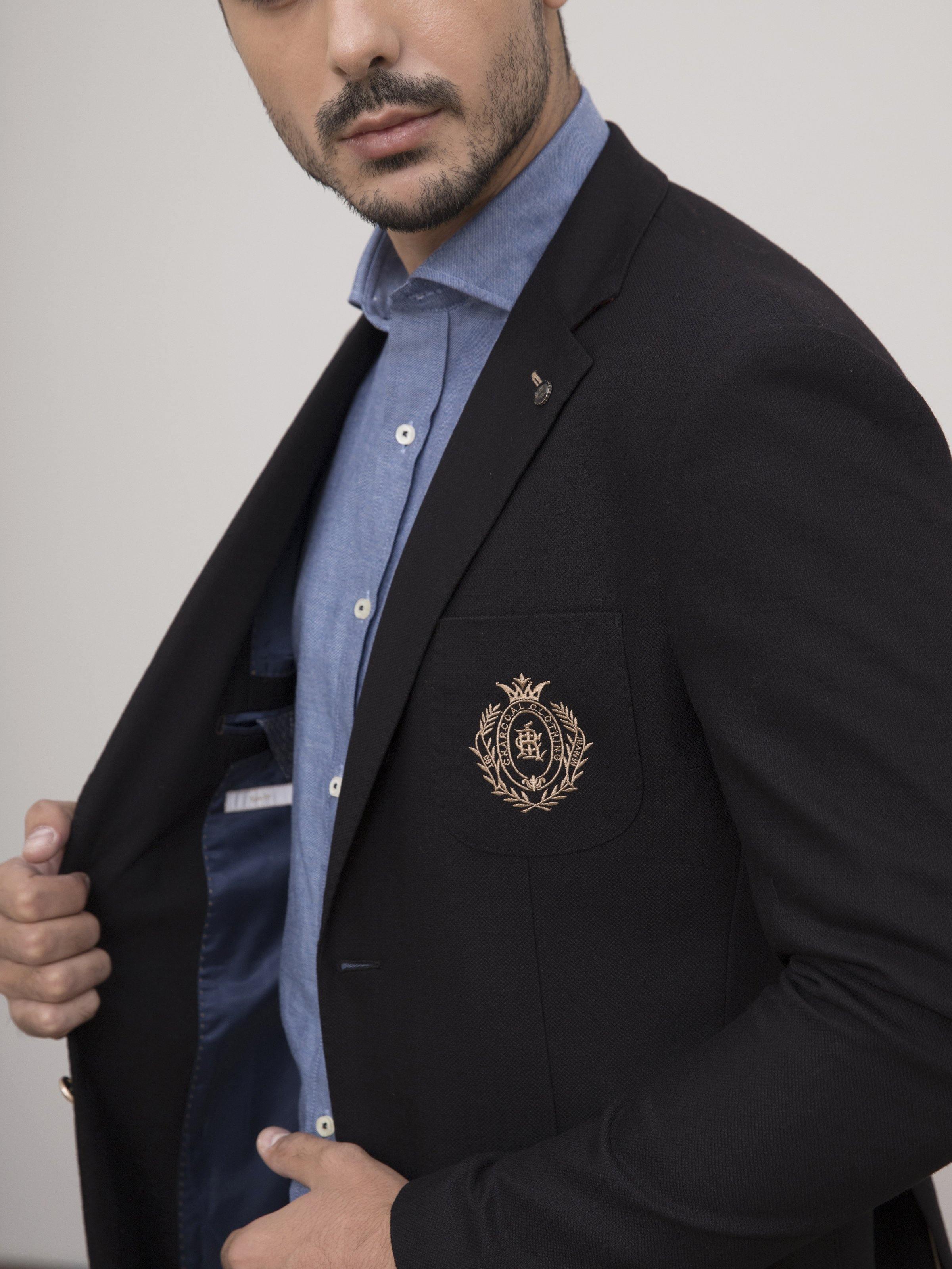 Black coat lapel detail with crest emblem and gold trim buttons.
