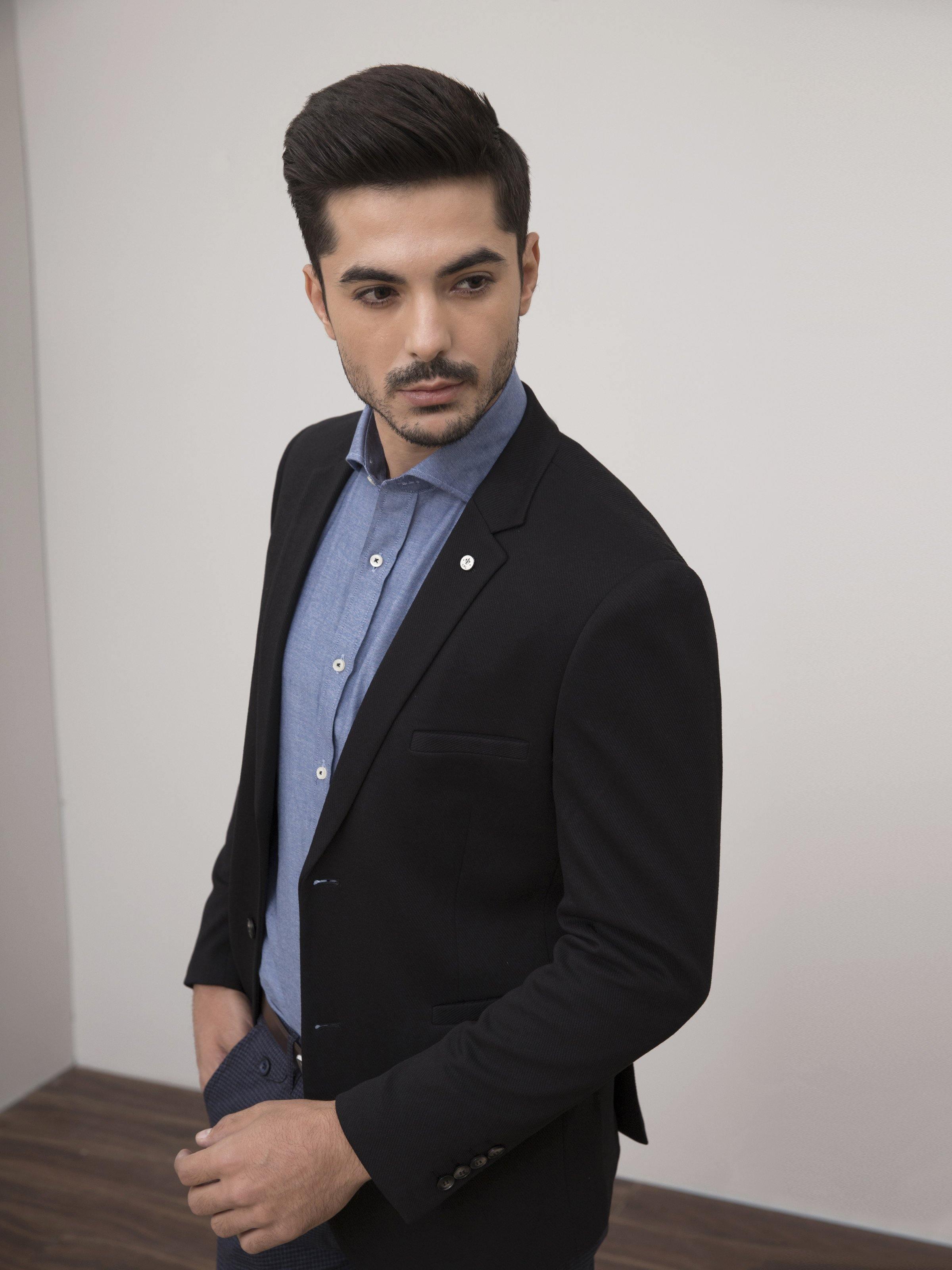 Black slim-fit single-breasted coat with notch lapels and front pockets, worn over shirt