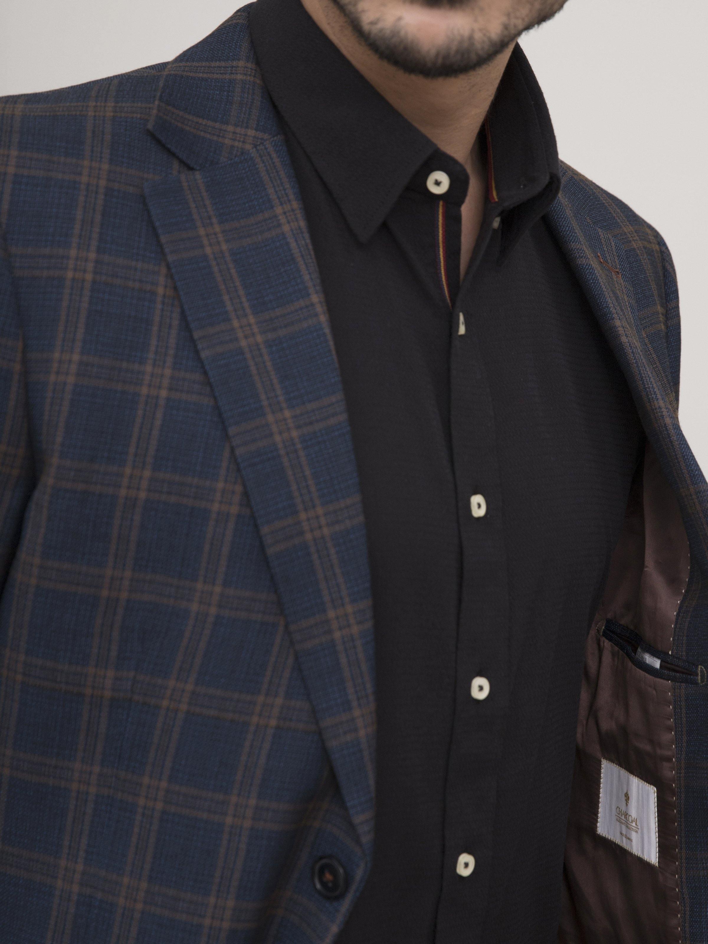 Navy-brown plaid coat lapel detail with dark button placket and pocket opening