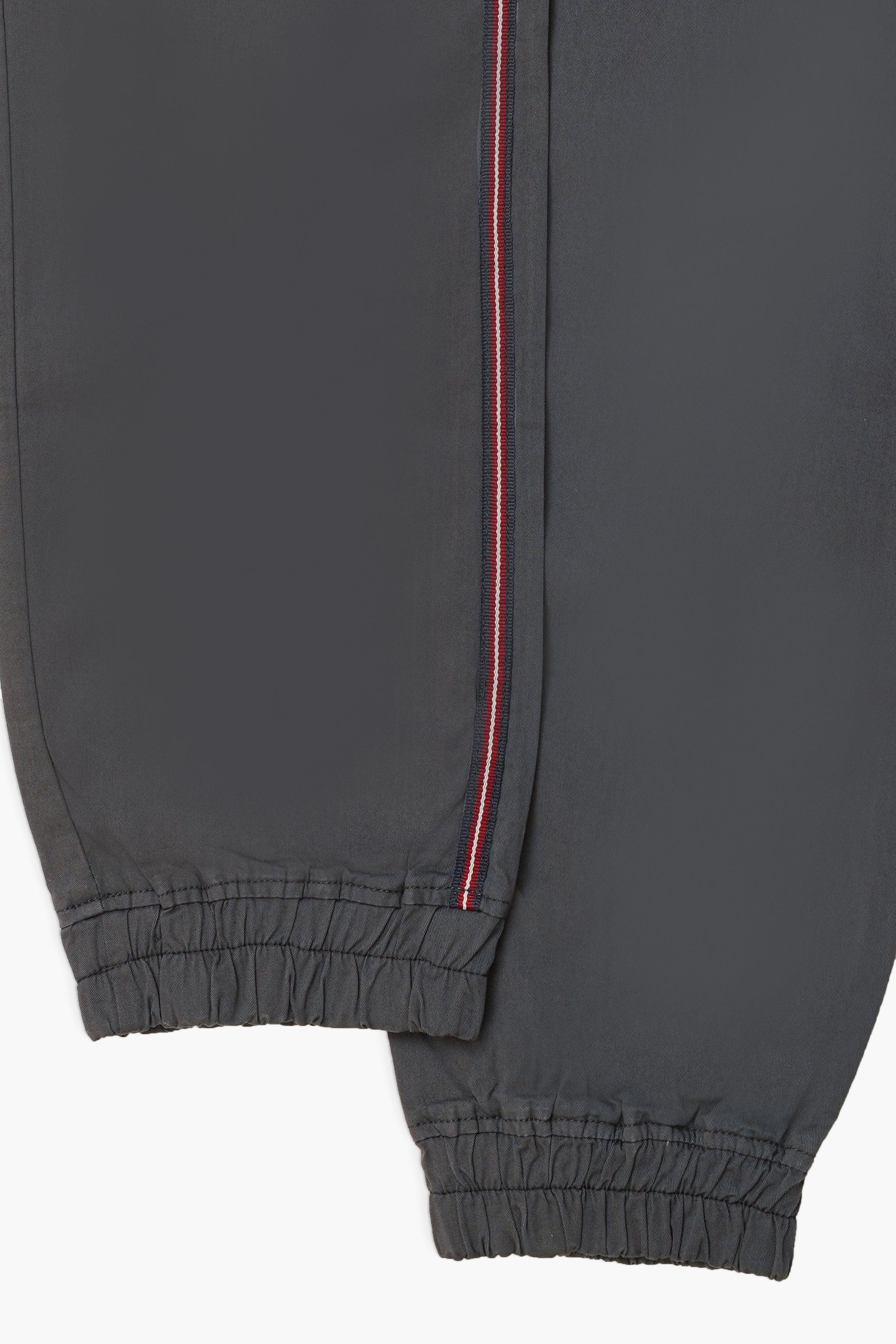 Dark grey jogger trousers with red vertical stripe and ribbed elastic cuffs