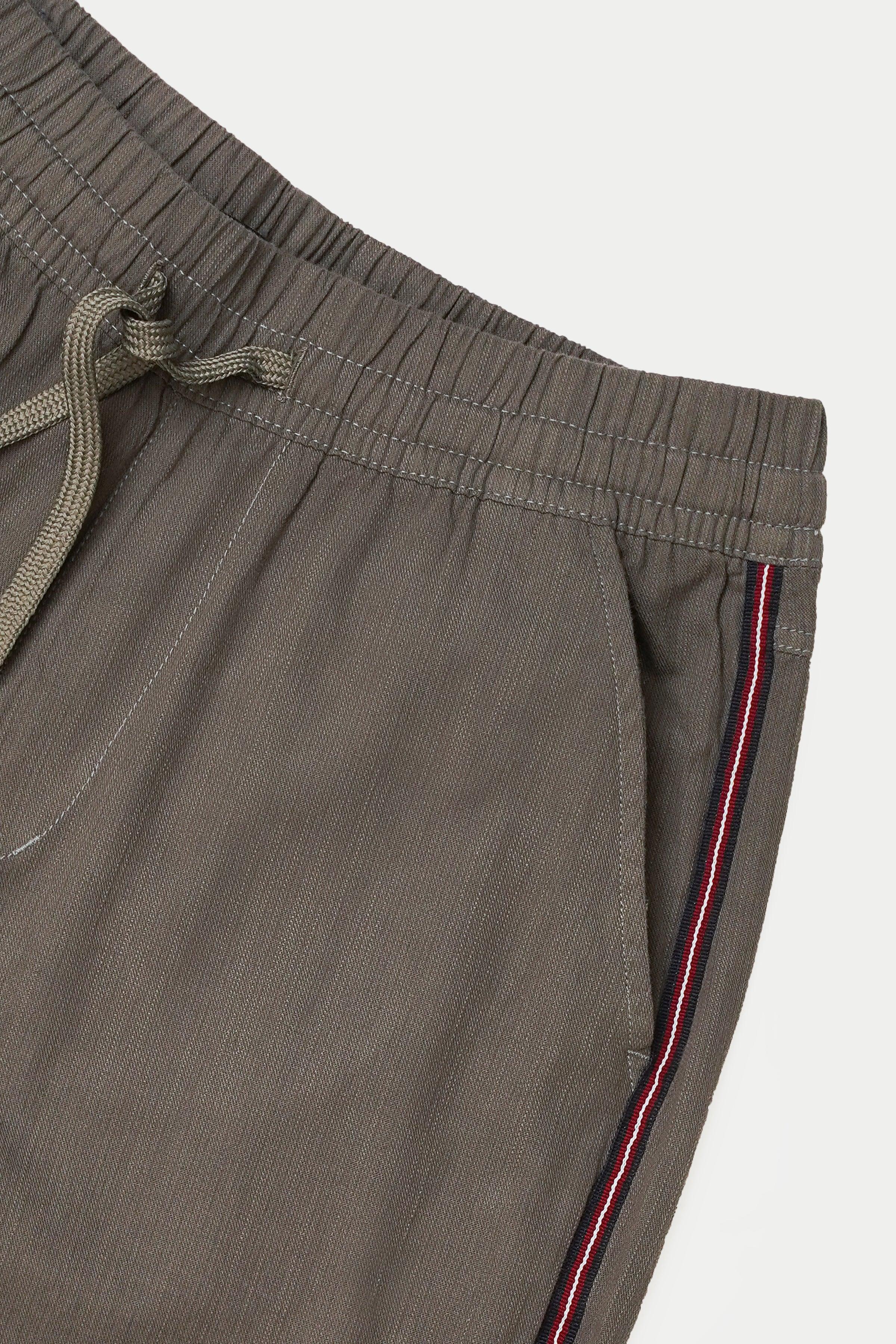 Grey jogger trousers close-up: elastic waistband, drawstring, side stripe detail