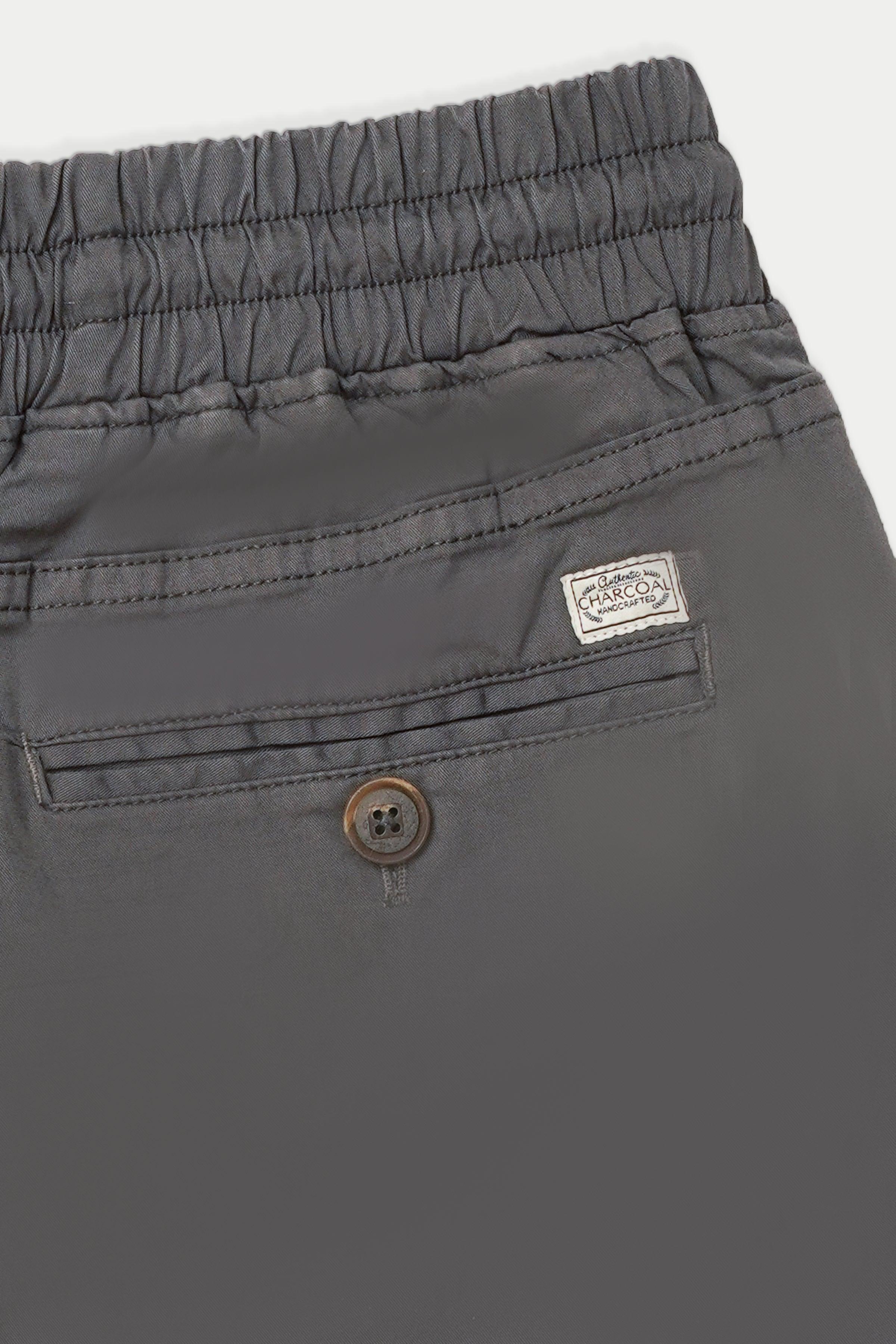 Grey jogger trousers with elastic waistband, button closure, fabric logo patch