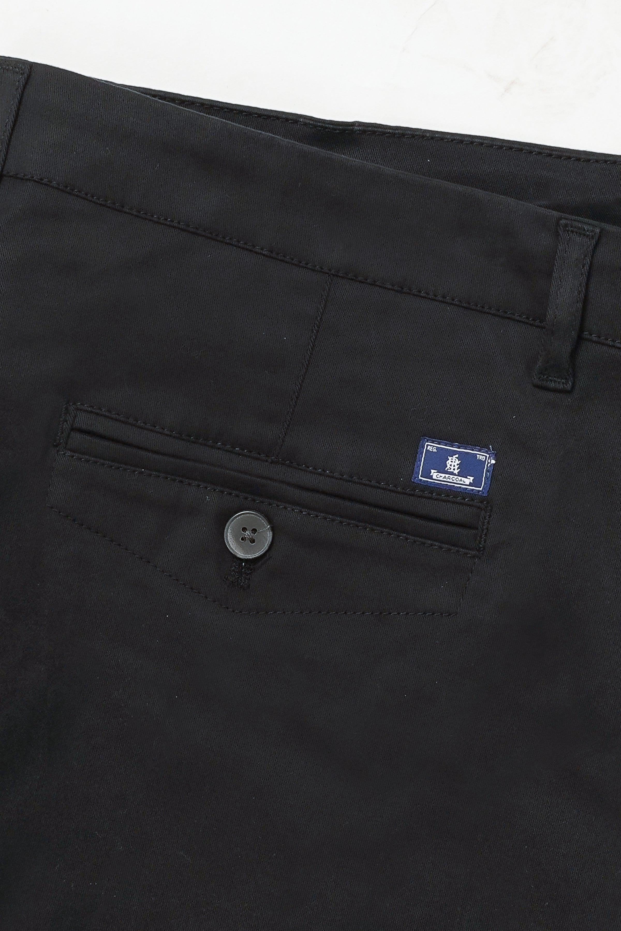 Black casual pants close-up with button, stitched pocket, and logo label