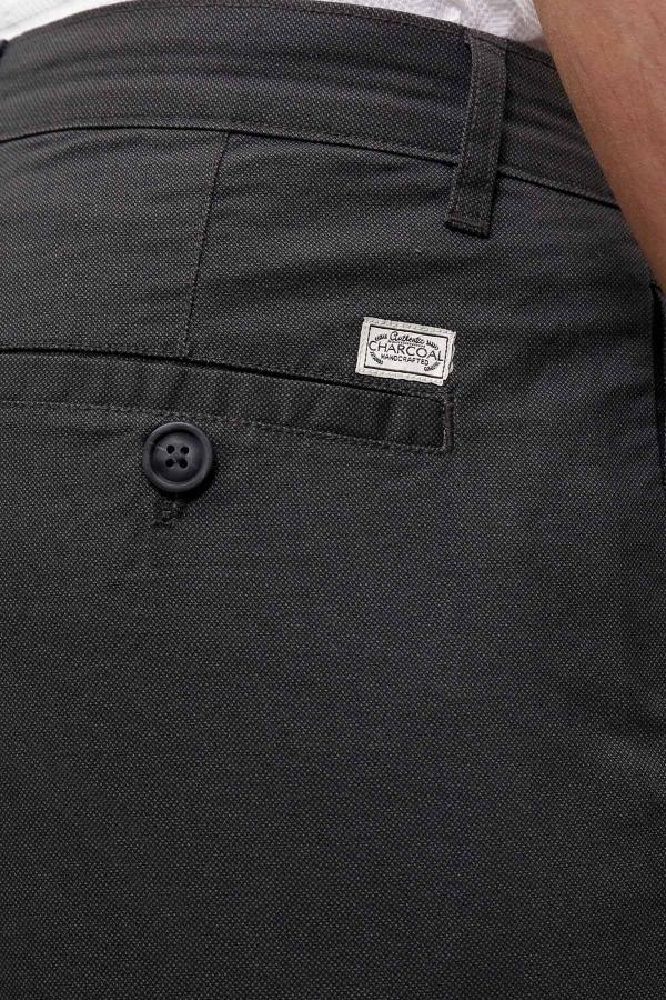 Dark grey pants close-up with button fly, logo patch, and belt loop