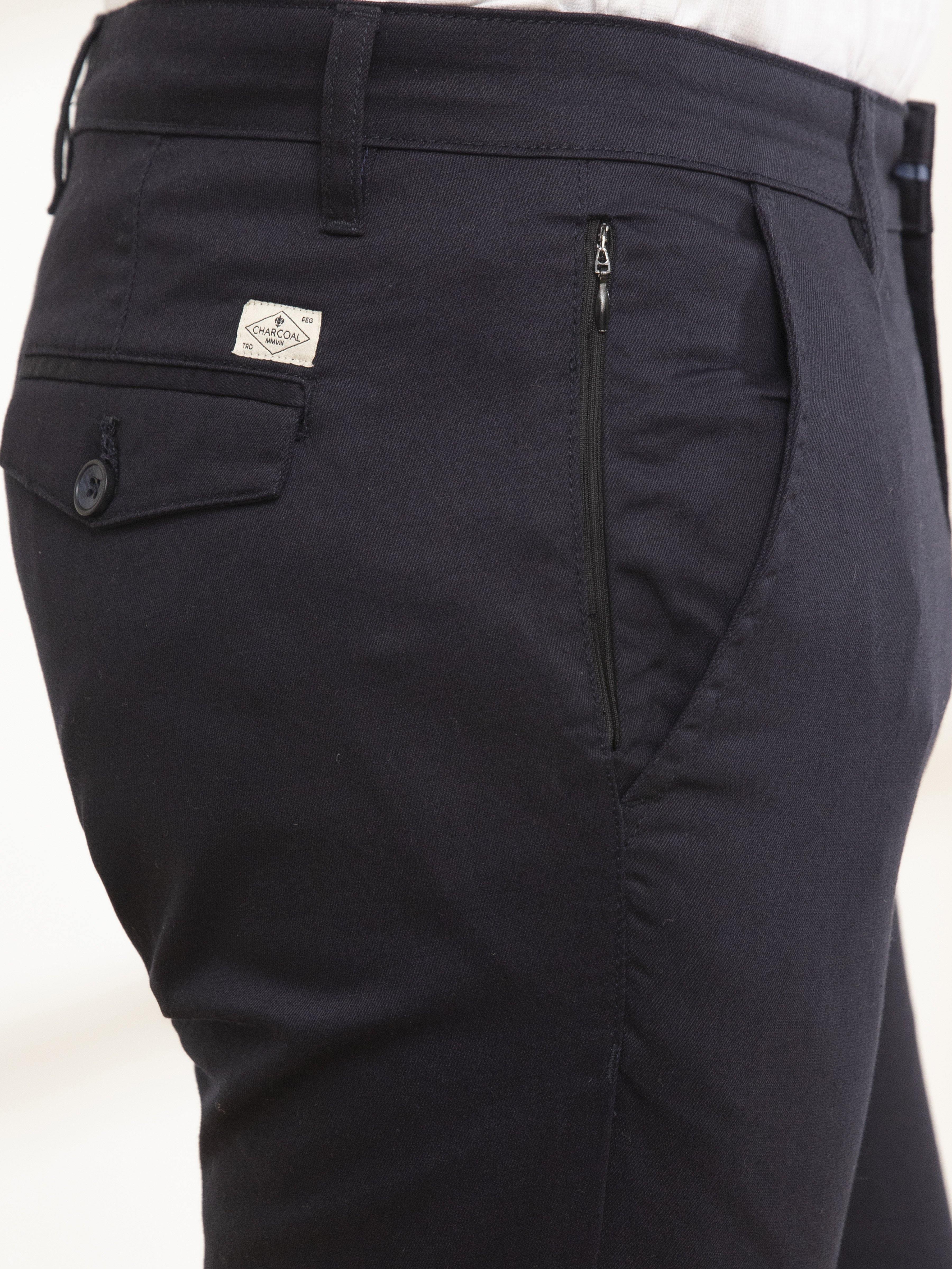 Navy casual pants close-up: logo patch, front pocket, and zip coin pocket