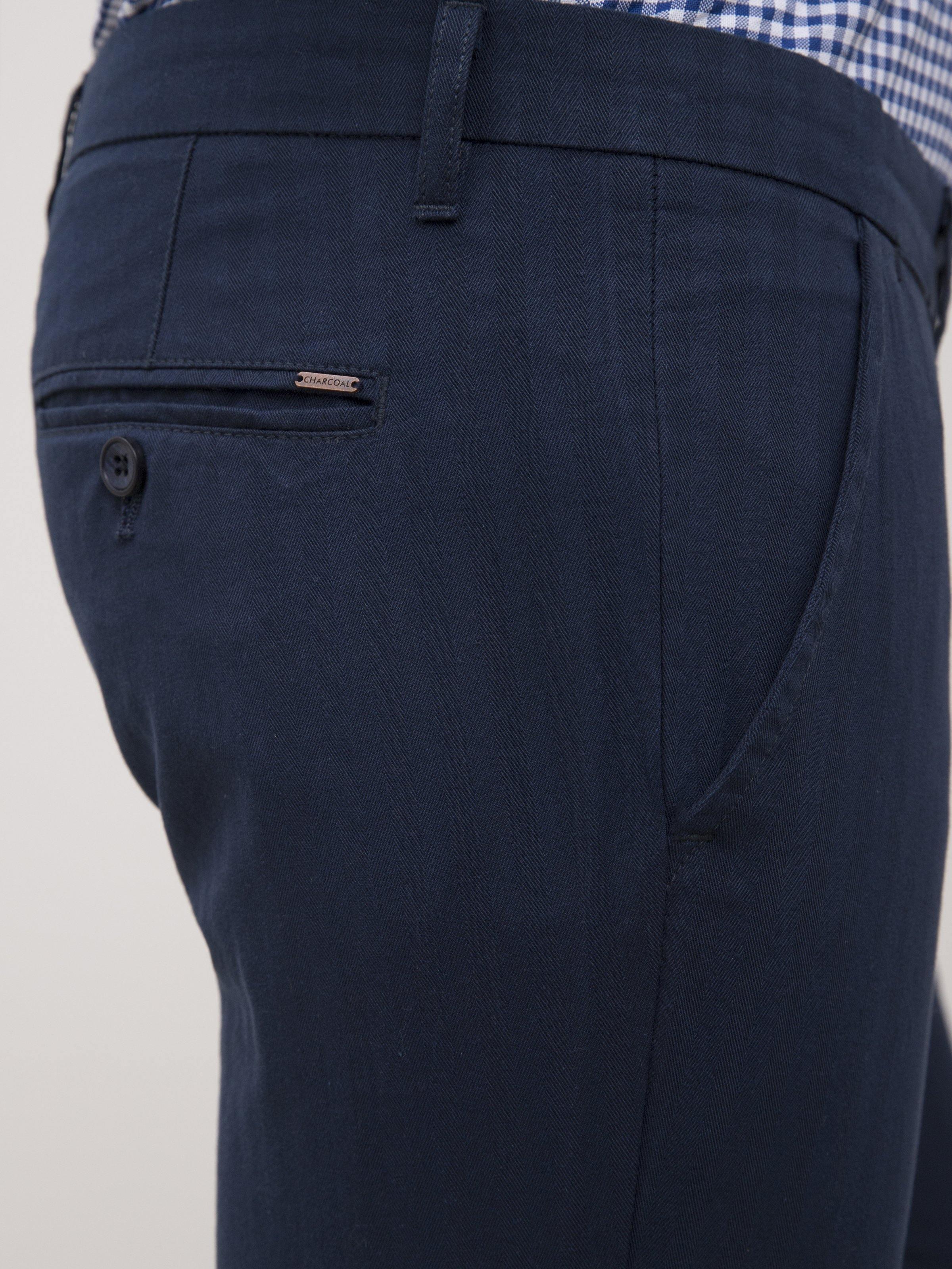 Navy slim-fit casual pants back view with welt pocket and stitched seams