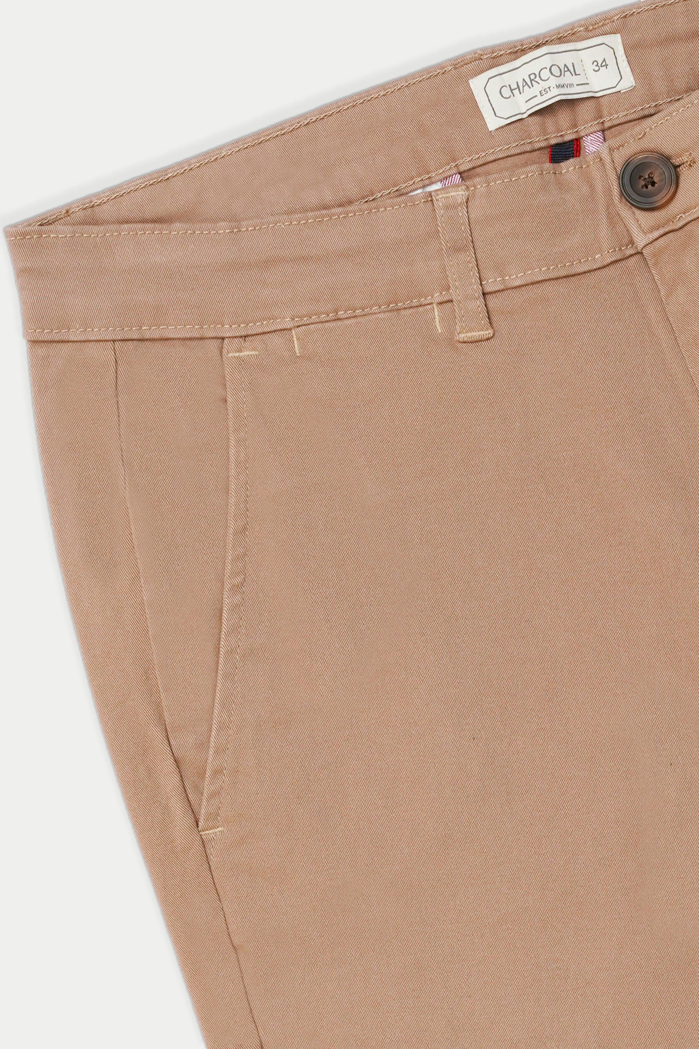 Light brown casual pants waistband close-up with belt loops and button closure.