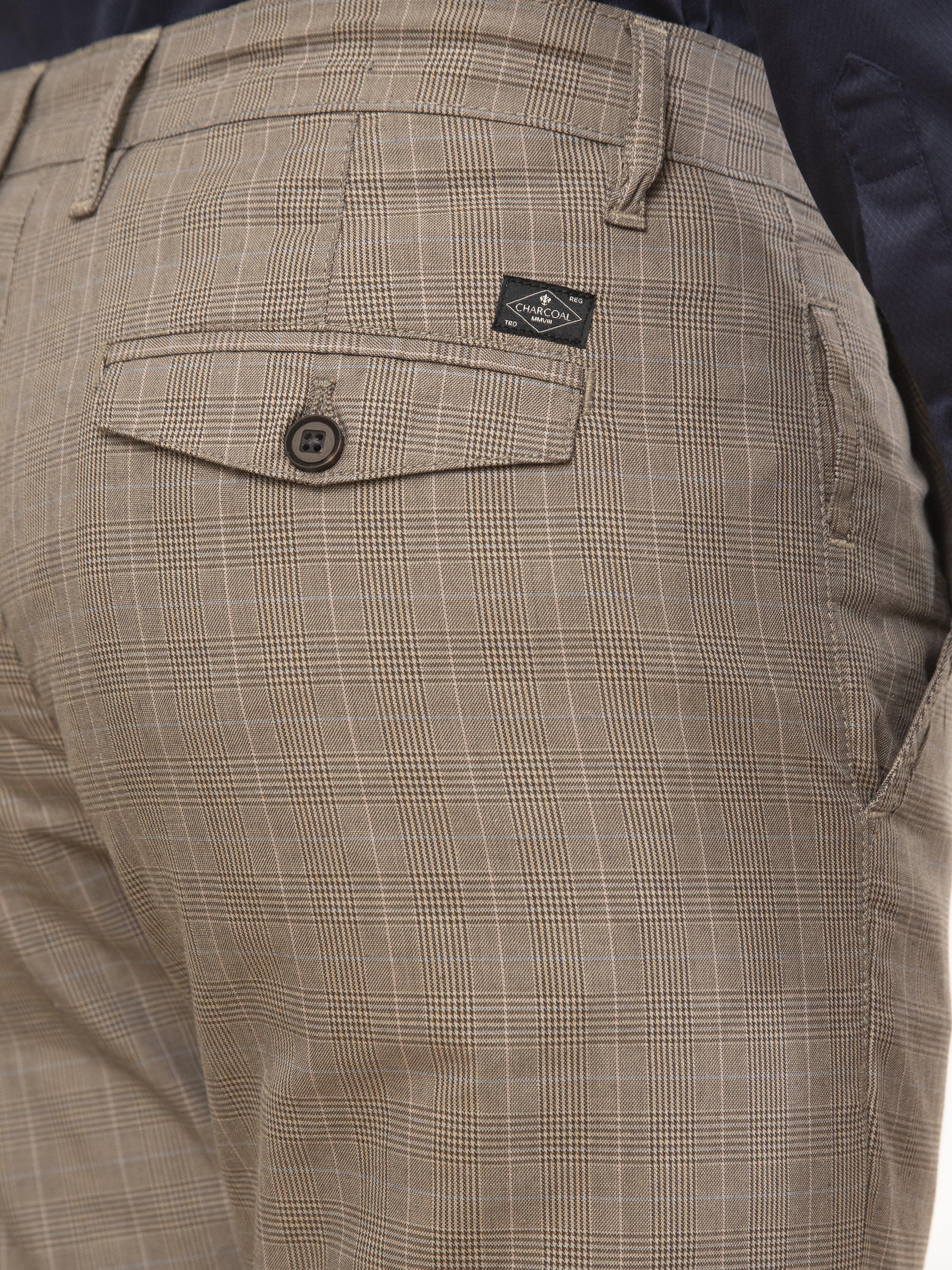 Slim-fit casual pants close-up: plaid fabric, buttoned flap pocket and logo tag