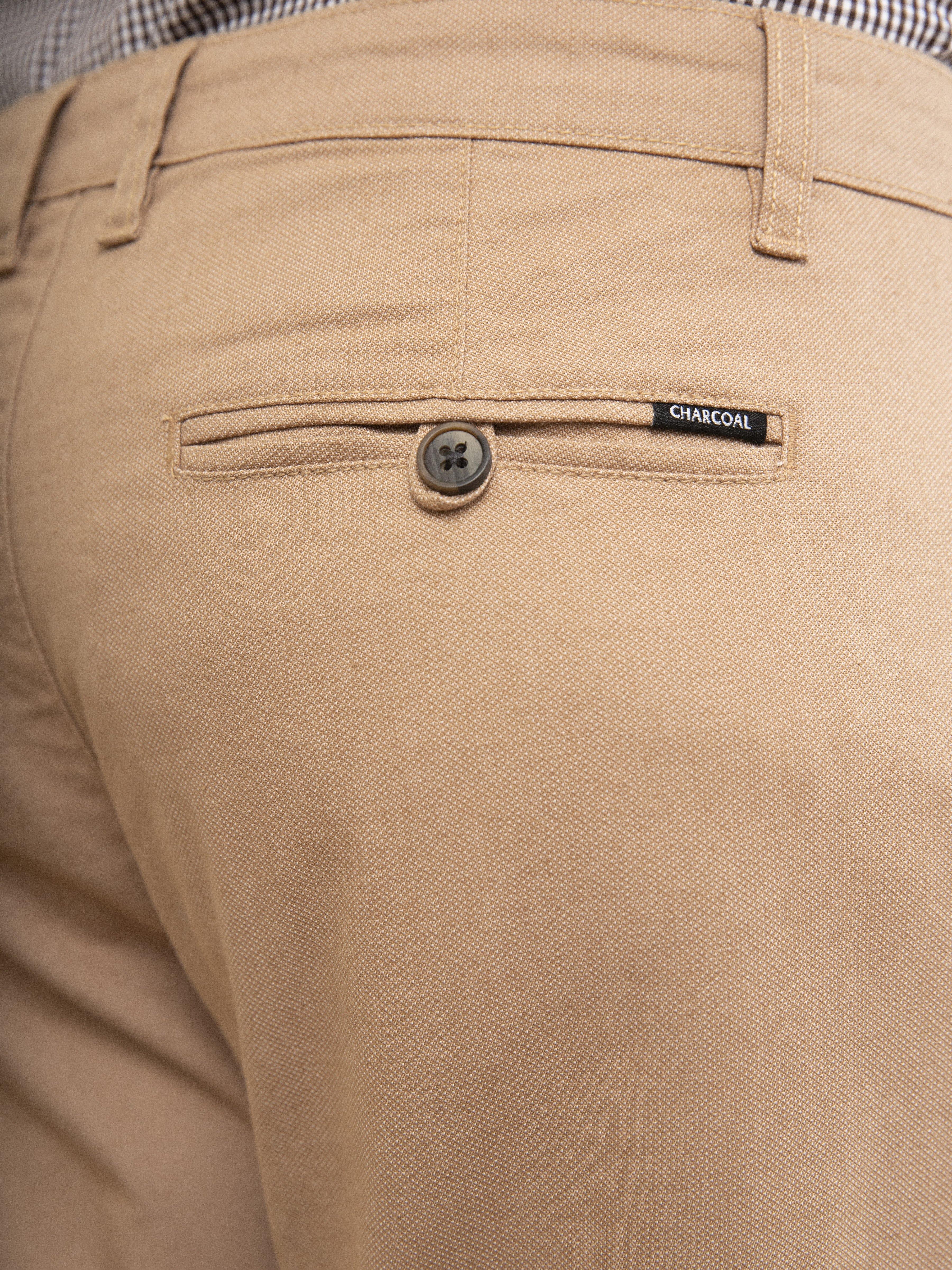 Khaki front pocket panel with button and small label reading CHARCOAL