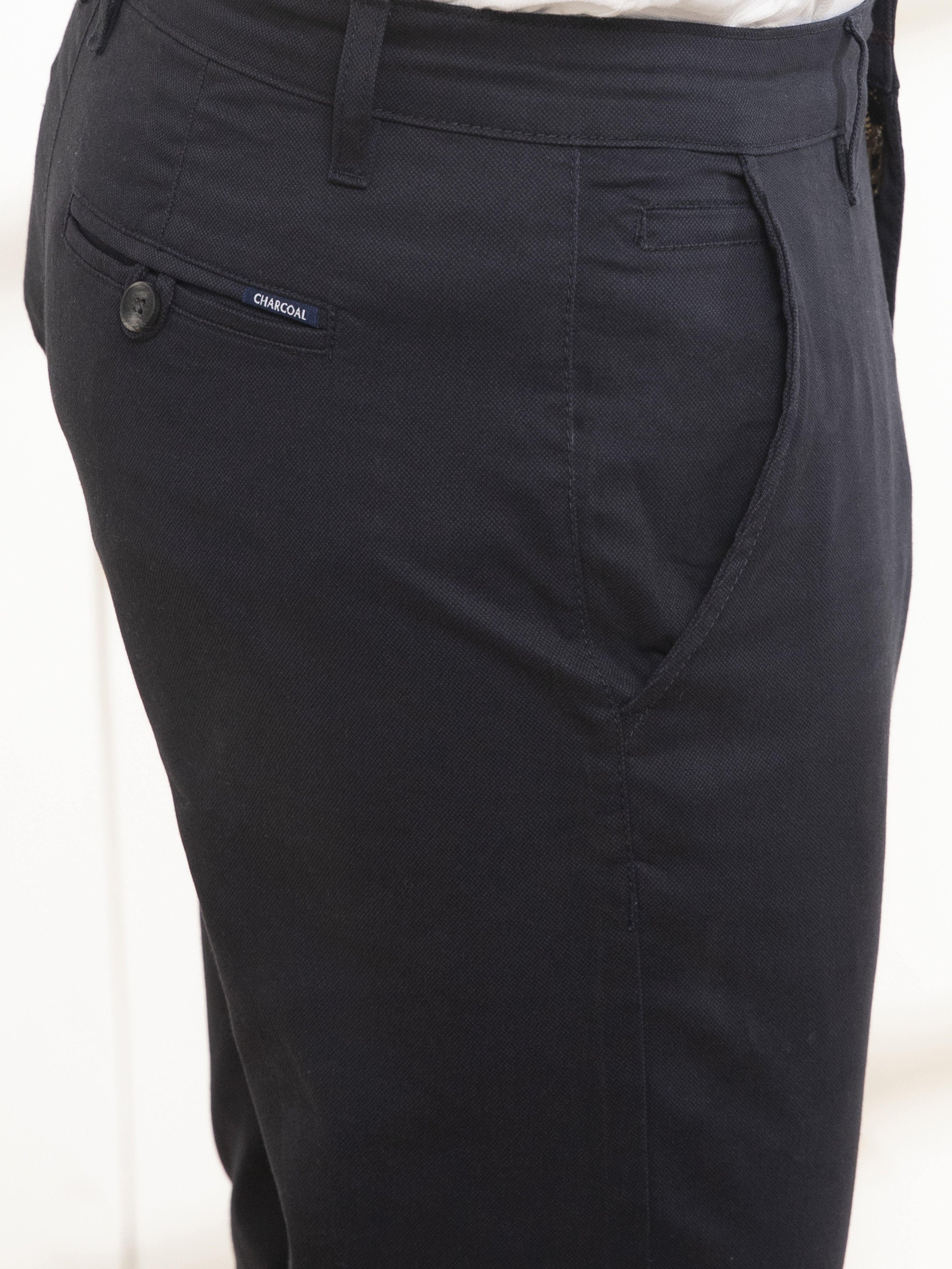 Slim-fit casual pants close-up, dark fabric, side pocket and coin pocket