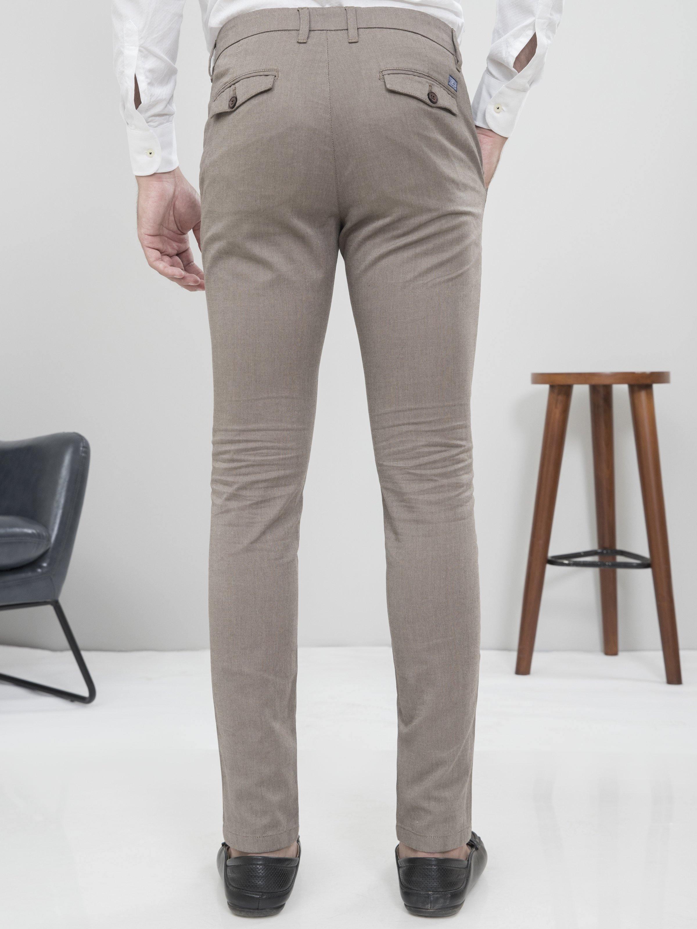 Light brown slim-fit casual pants on model, showing back waistband and tapered fit
