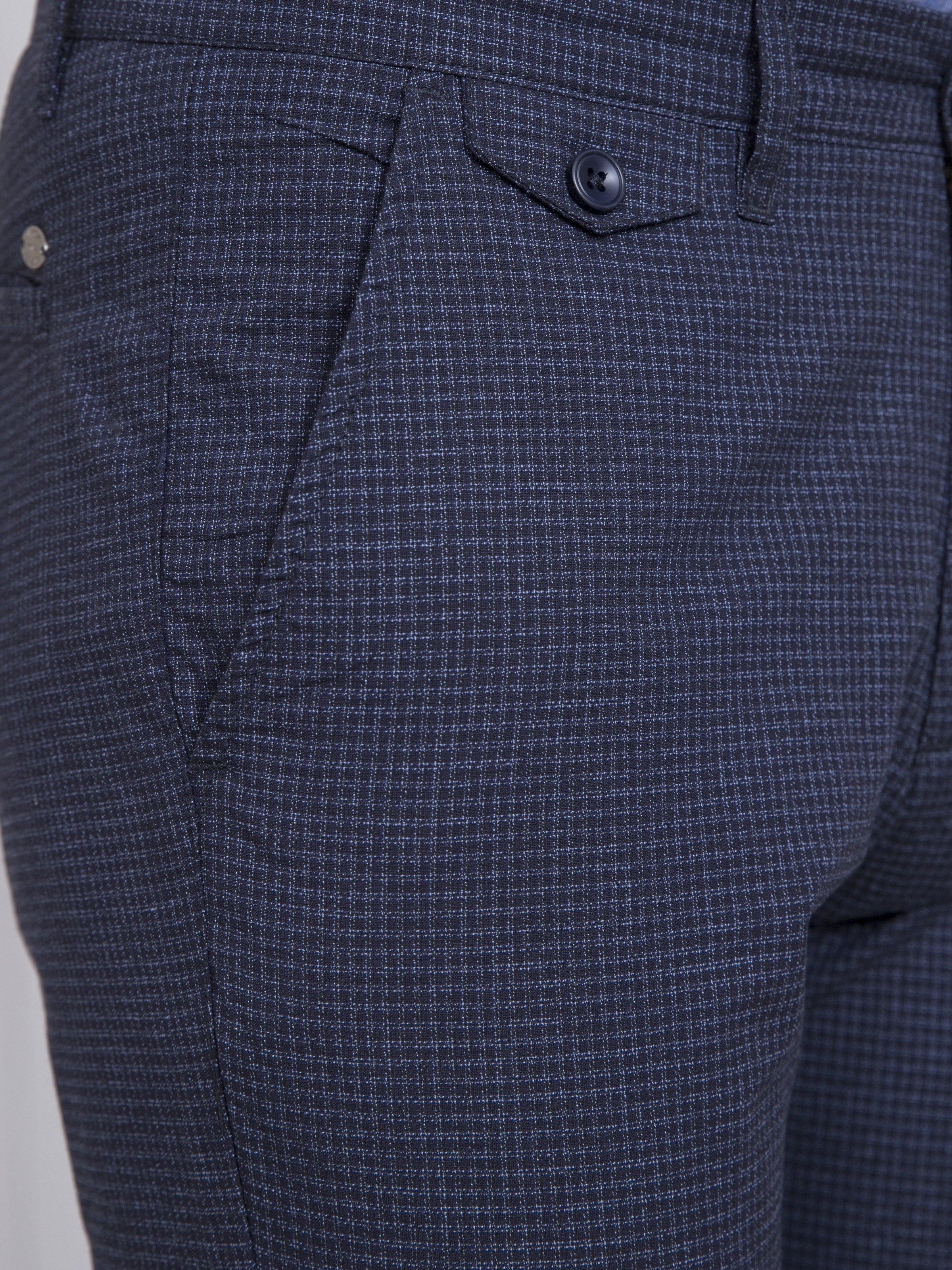 Slim-fit casual pants closeup: dark navy check front pocket with button and seam lines