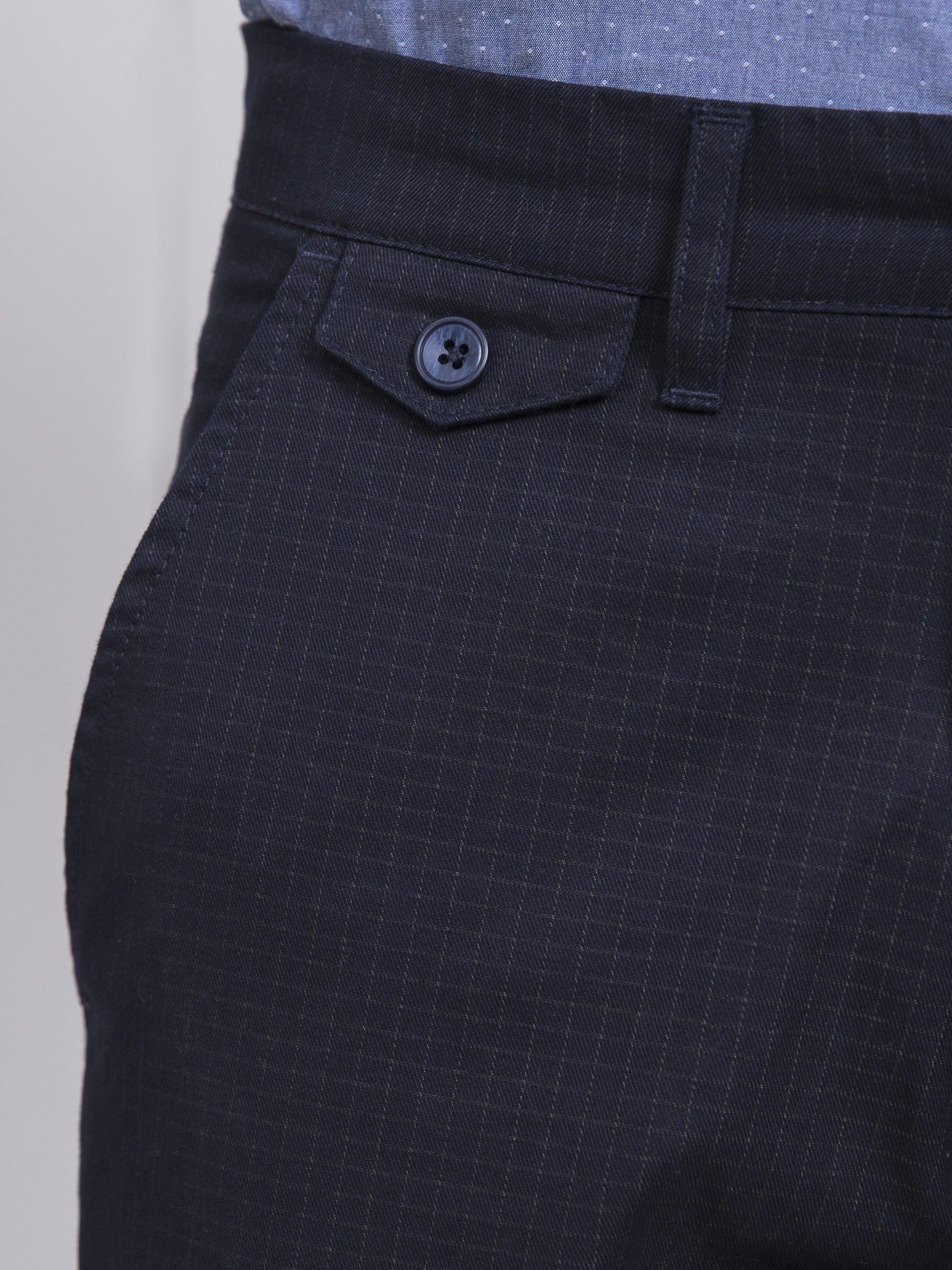 Navy casual pants close-up of front pocket with button detail.