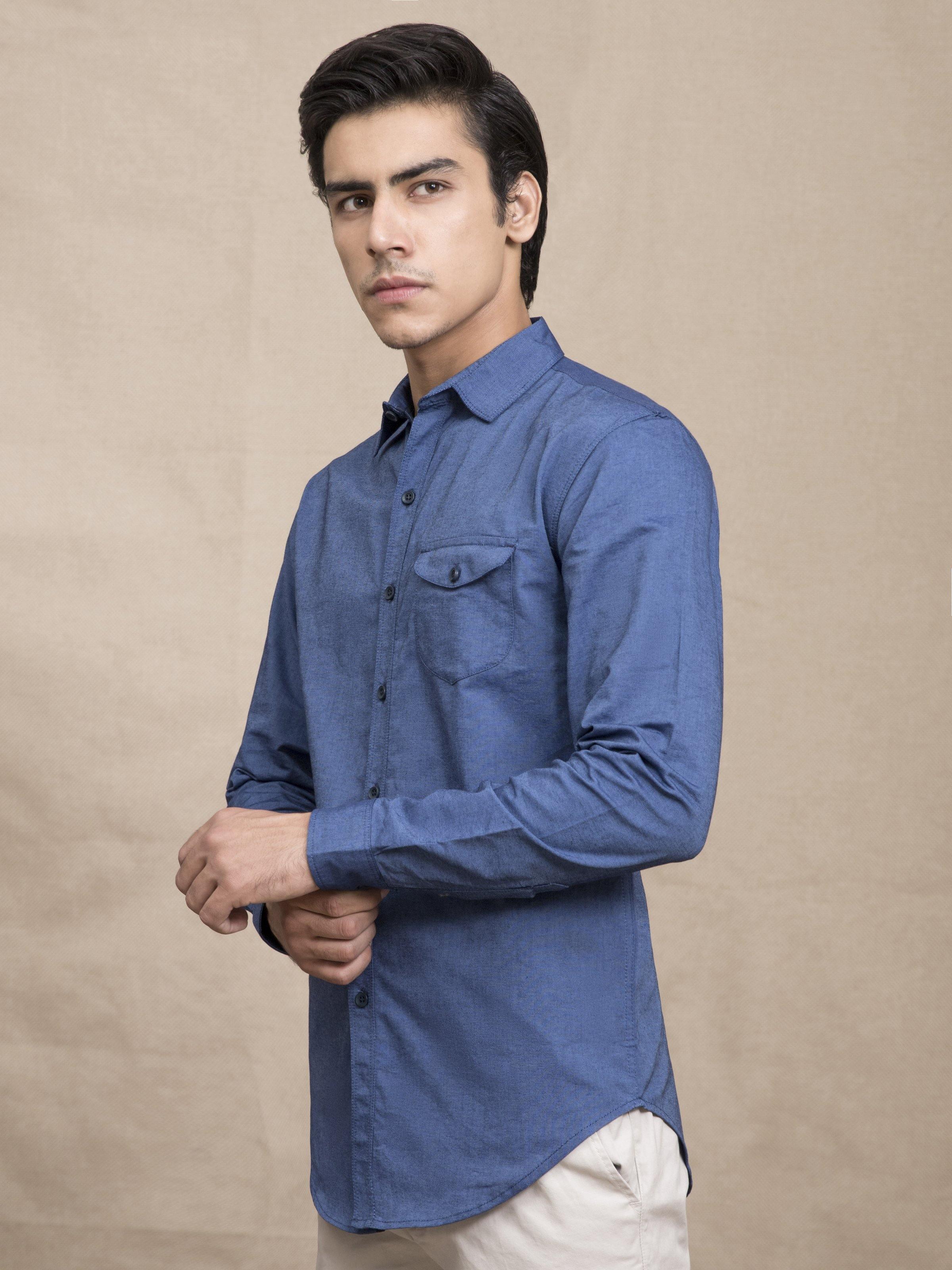 Blue casual button-down shirt with chest pocket and button cuffs, side view
