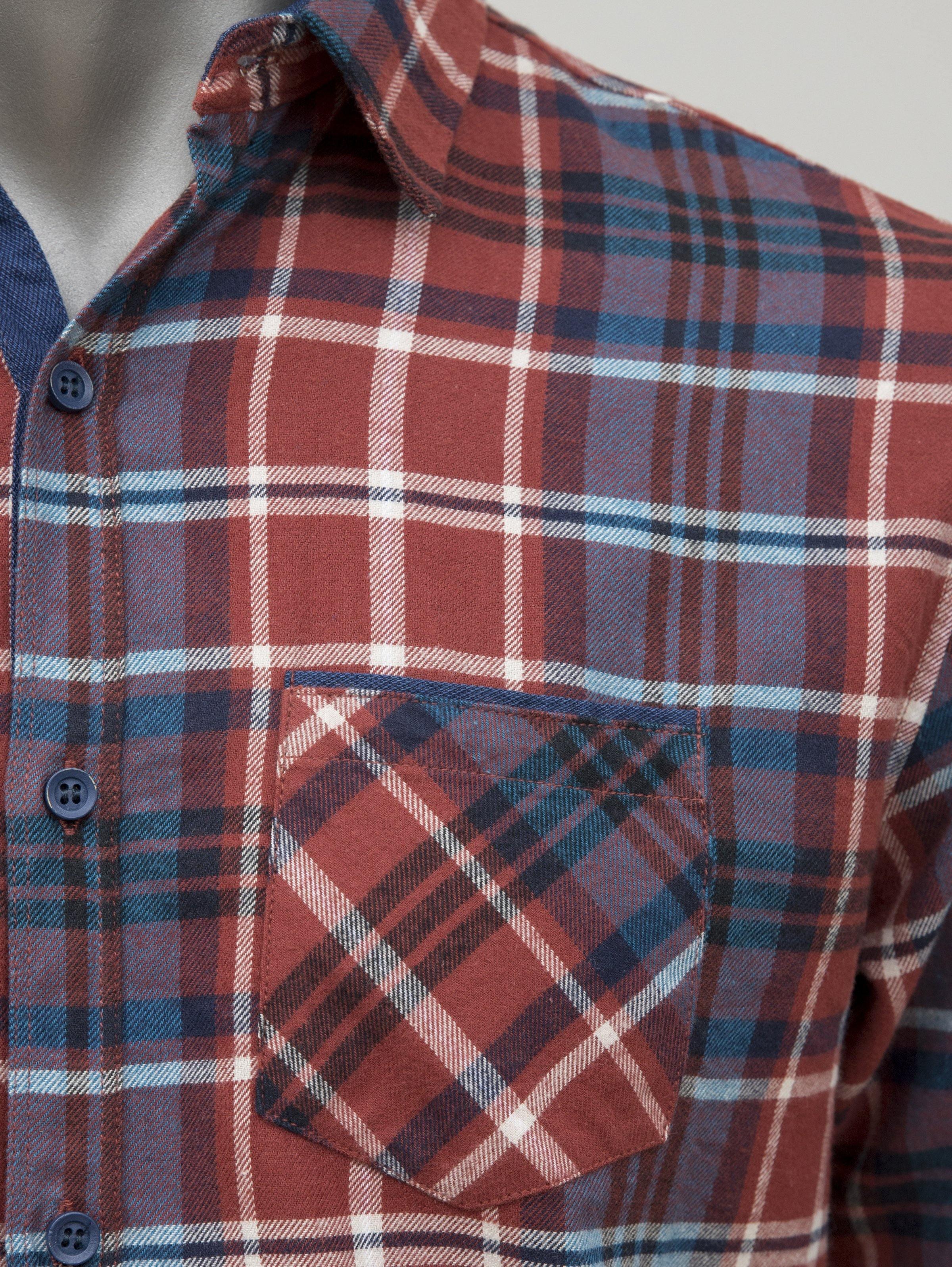 Rust plaid chest pocket with flap, button-up front and contrast blue details