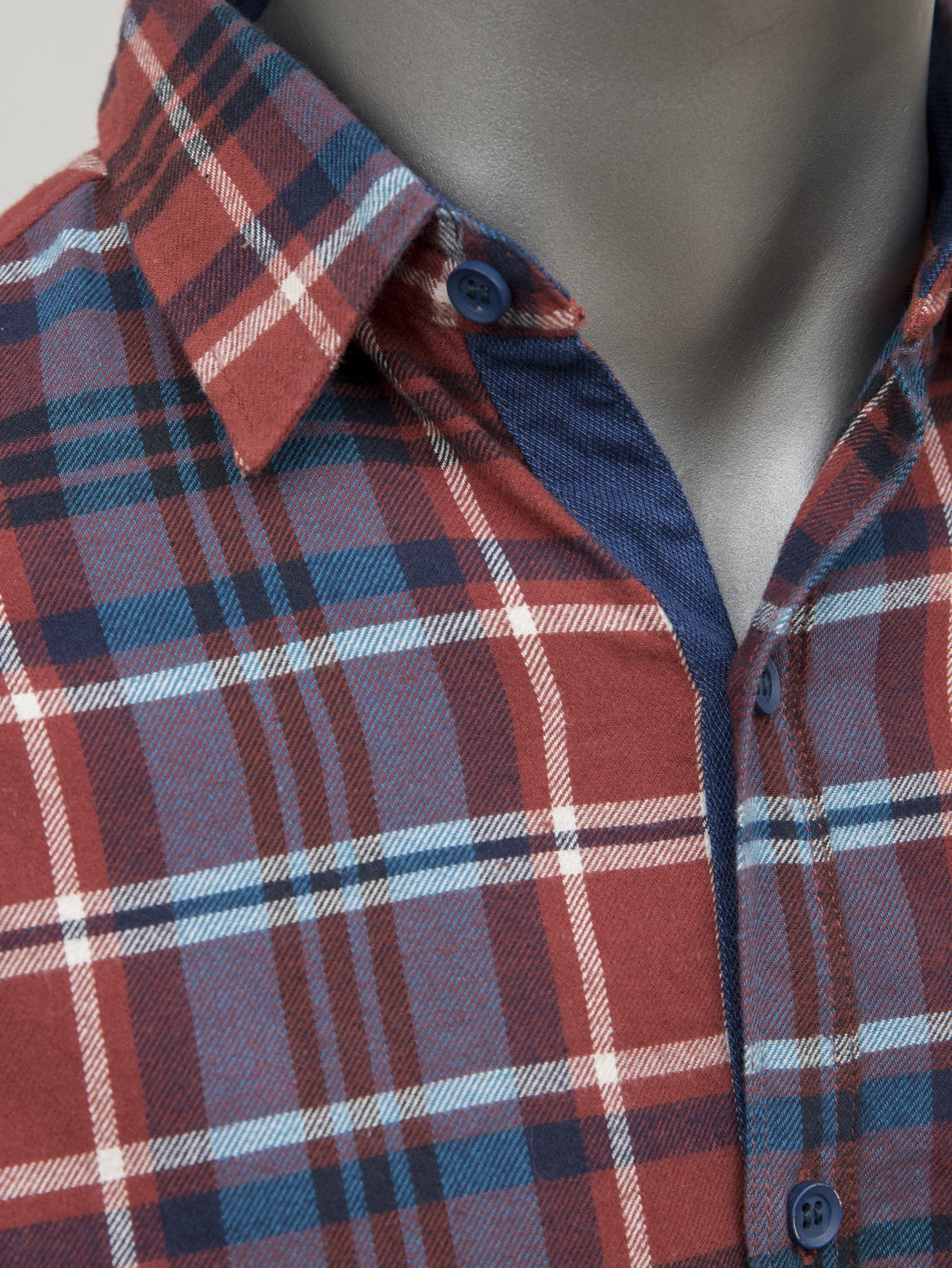 Rust plaid button-up shirt collar with long sleeves and dark blue button placket