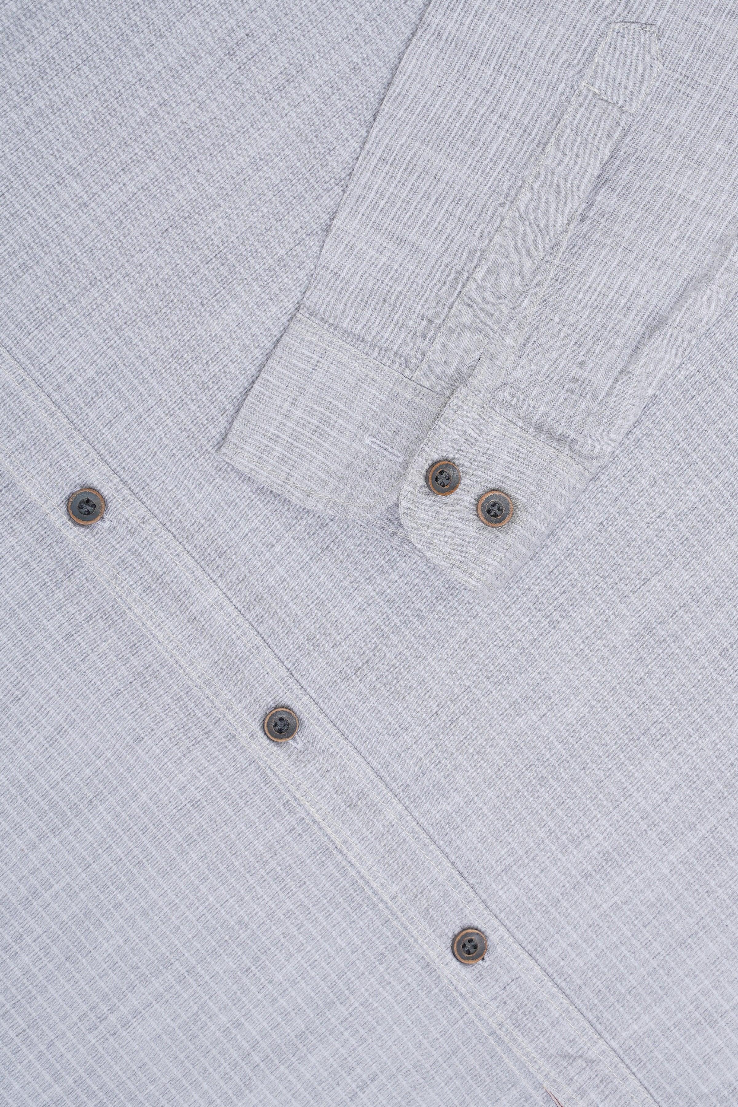 Light gray patterned shirt cuff with round buttons and long sleeves