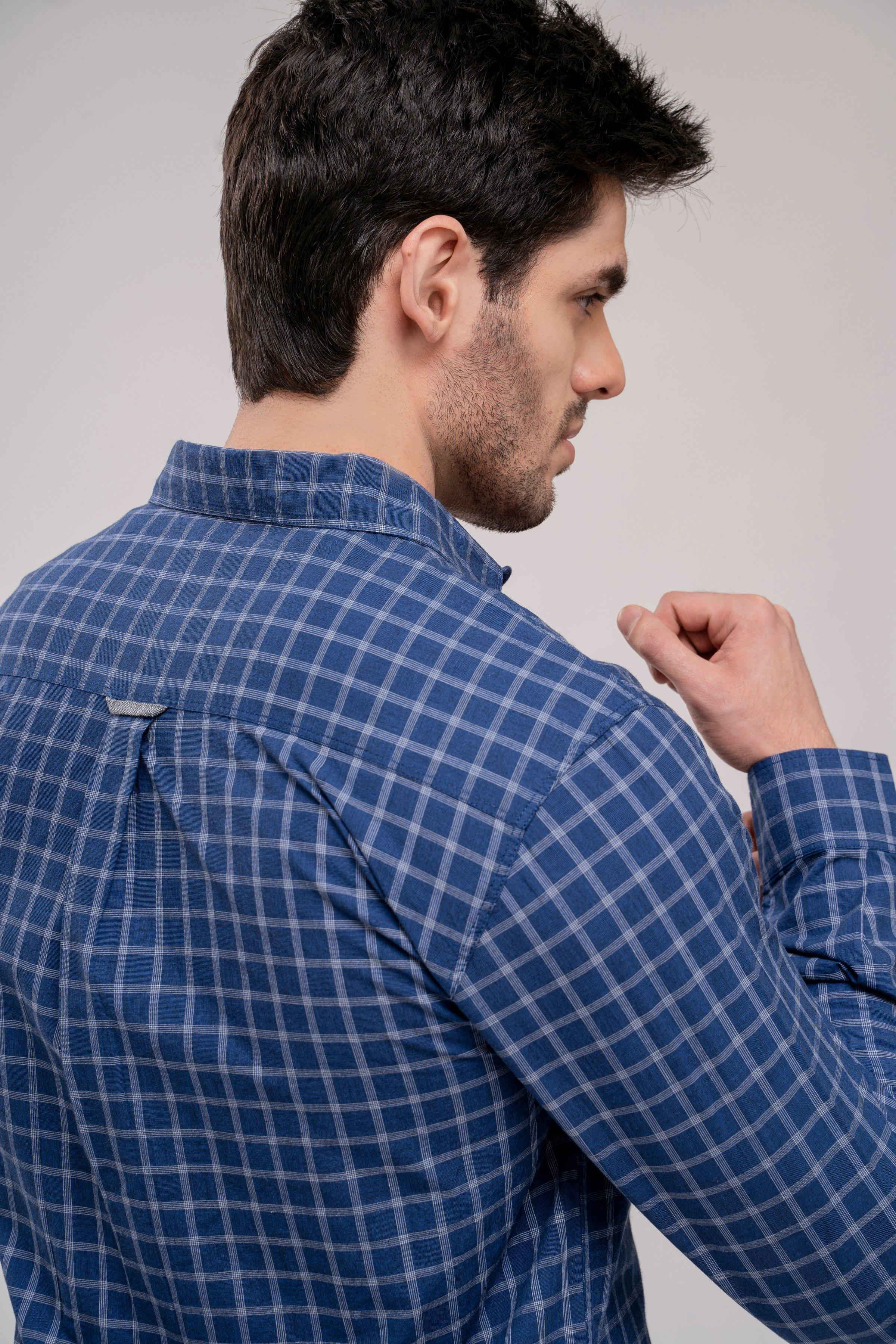Navy check shirt collar detail with button and folded fabric