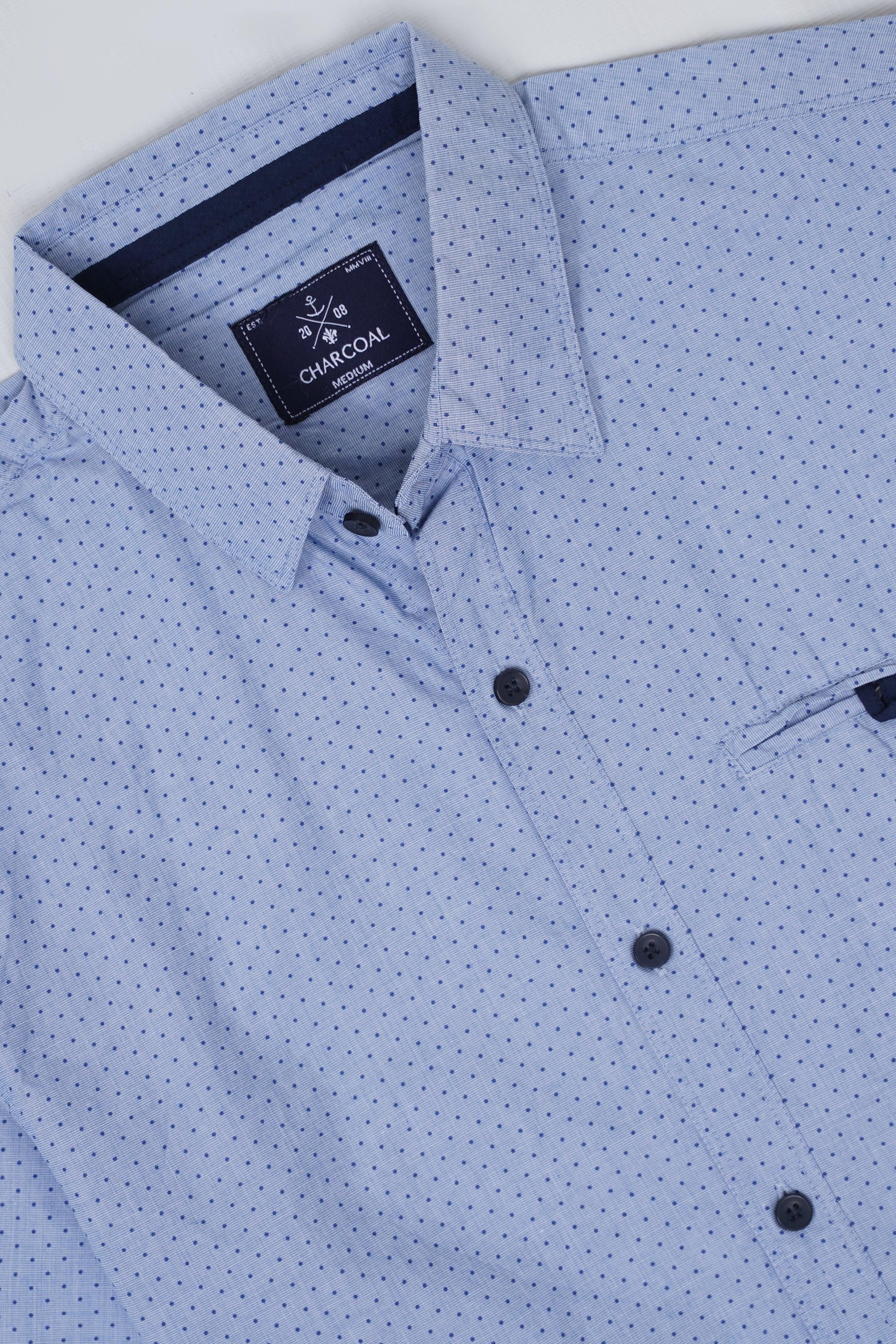 Men's button-up shirt close-up, light blue with small dot print and dark buttons