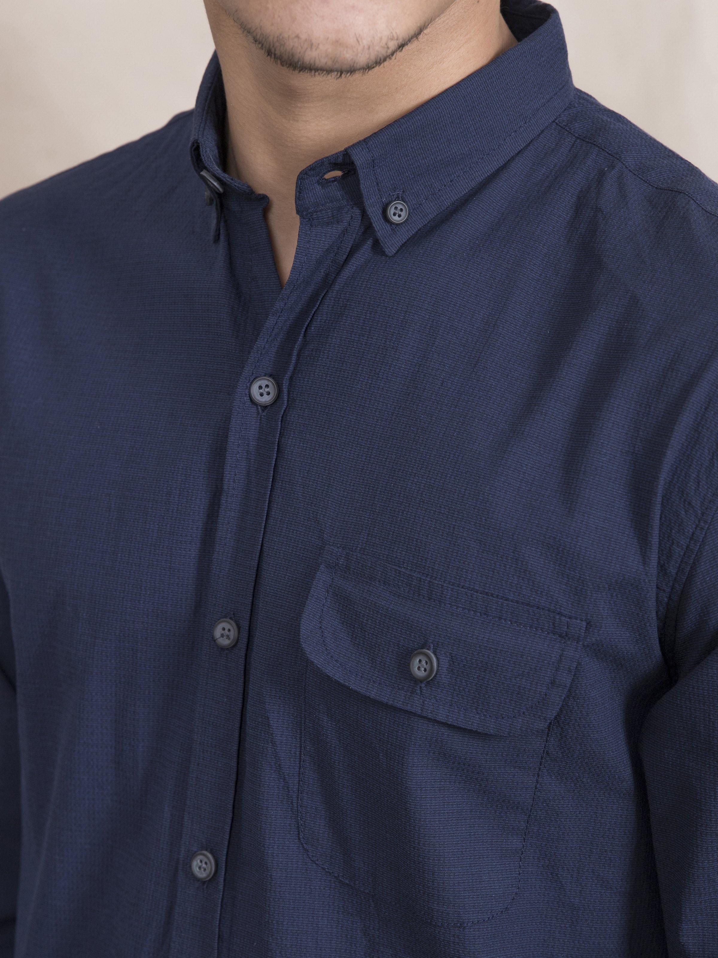 Navy button-up shirt collar with two-button placket and chest pocket close-up