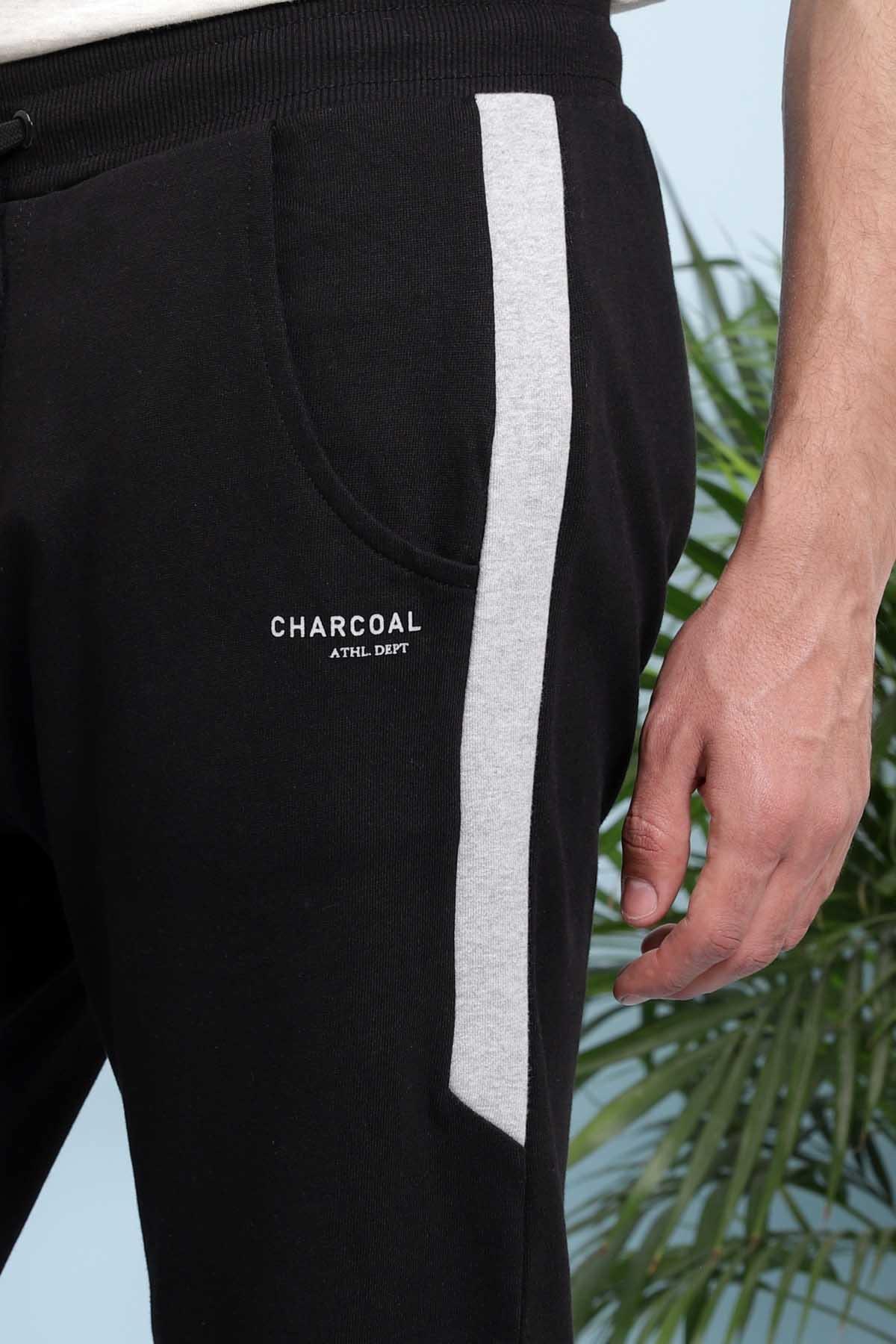 Black jogger trousers with charcoal text, vertical side stripe, and drawstring waist