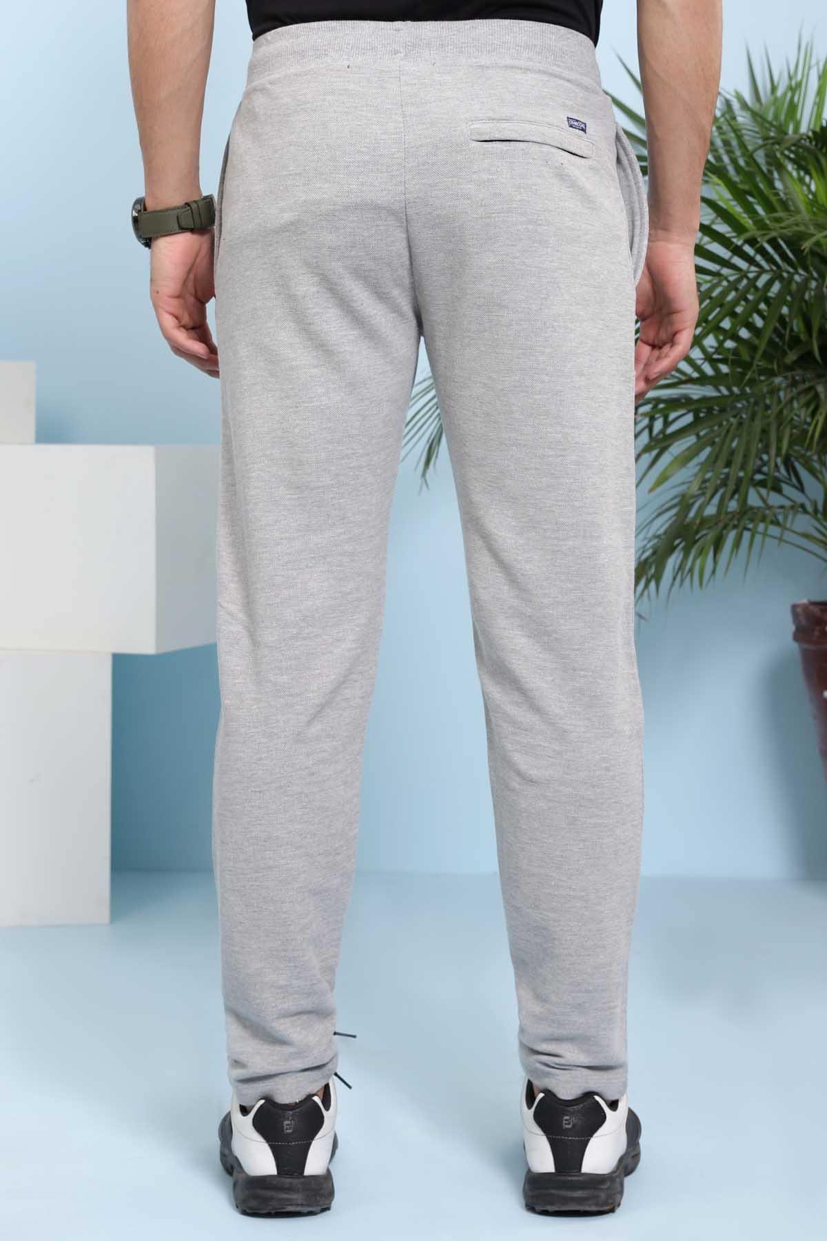 Grey casual trousers rear view with small logo patch and tapered fit