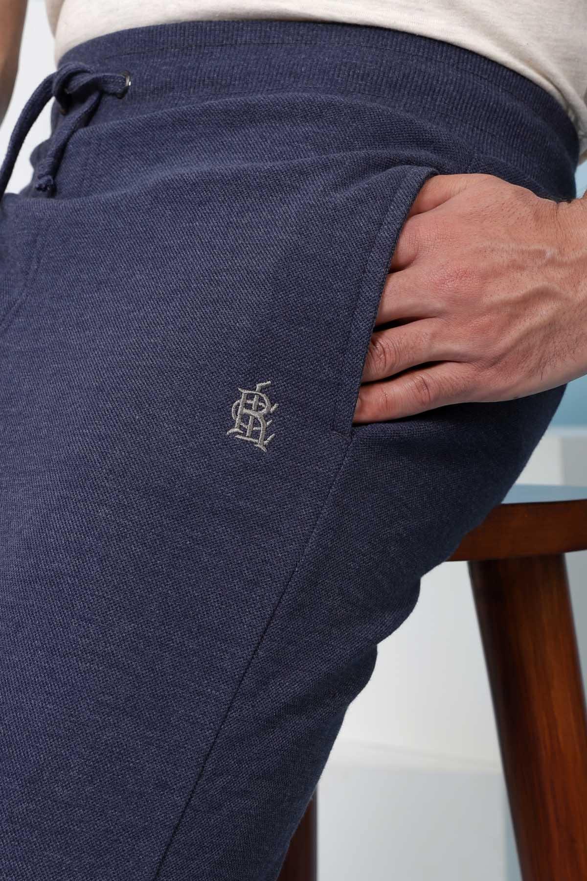 Indigo casual trousers with embroidered emblem on the front leg