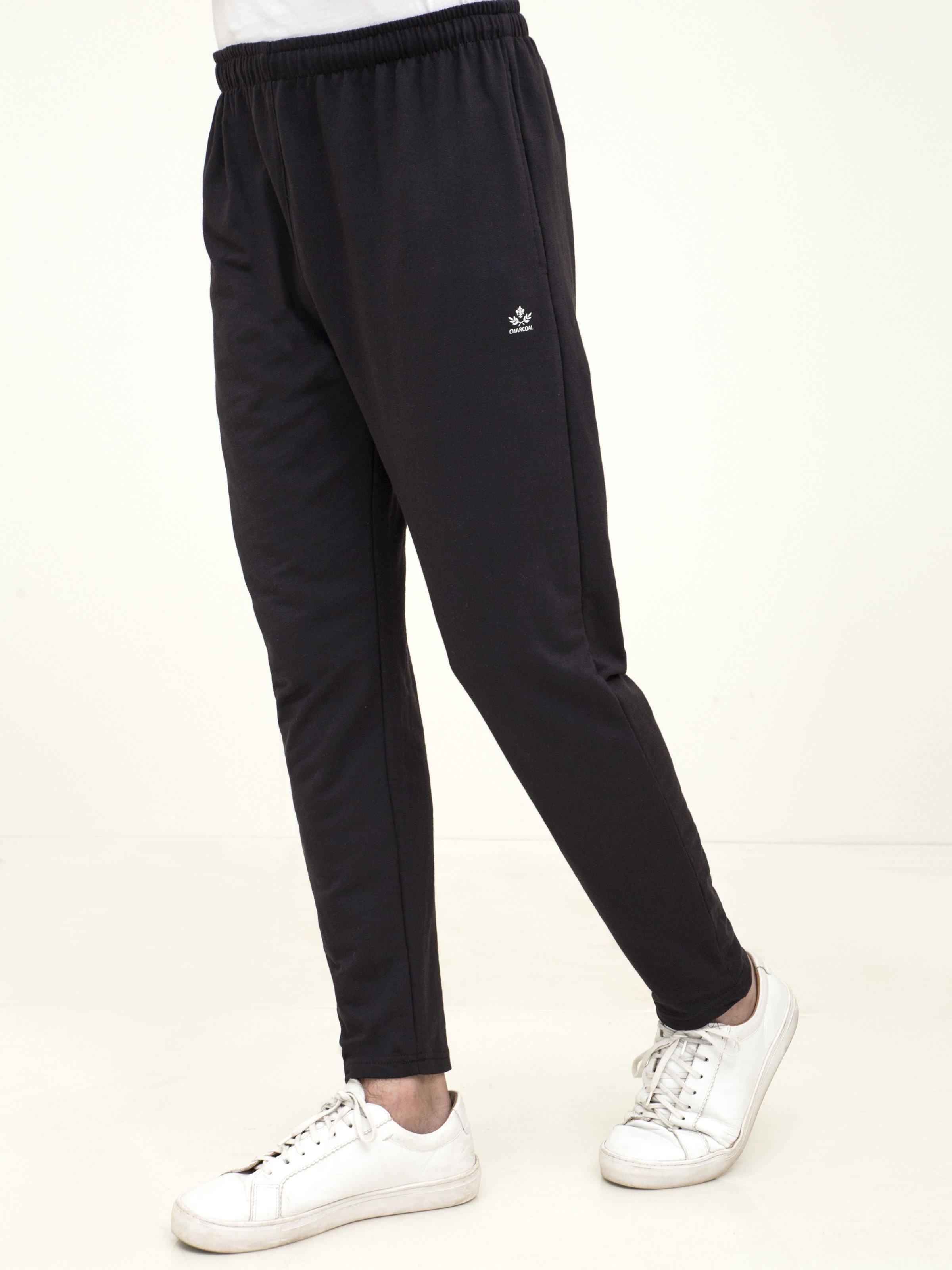 Black knit casual sleep trousers with elastic waist and logo detail; tapered legs