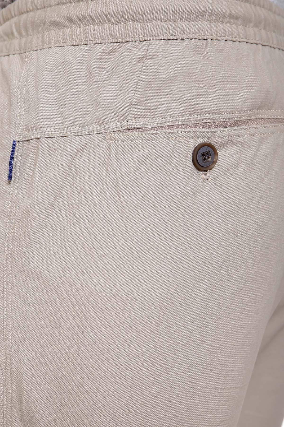 Light brown trouser waistband close-up with button, stitched seams and eyelet
