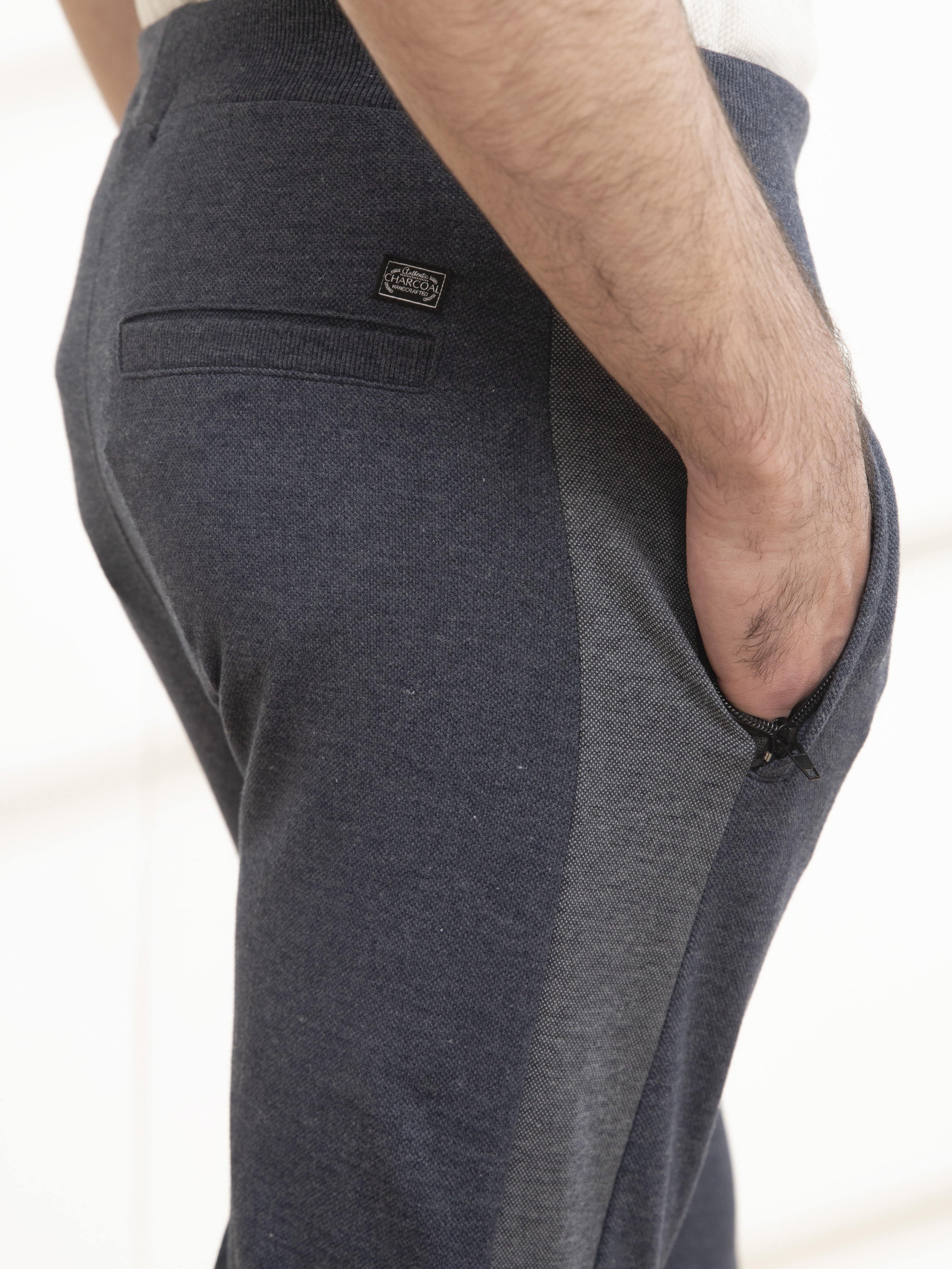 Indigo melange casual trousers close-up: side pocket and woven logo patch