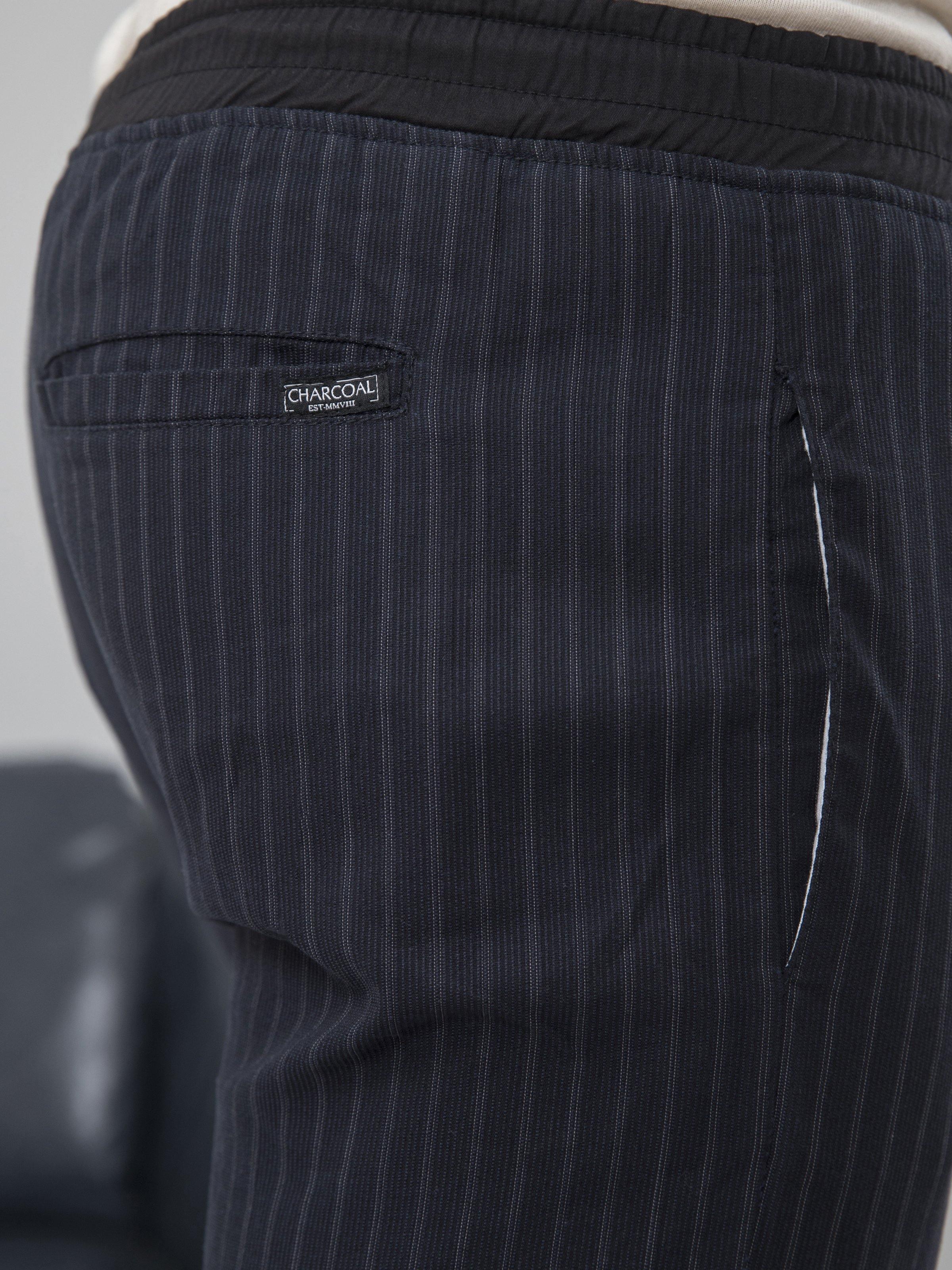 Charcoal grey trousers with elastic waistband and small logo patch at back