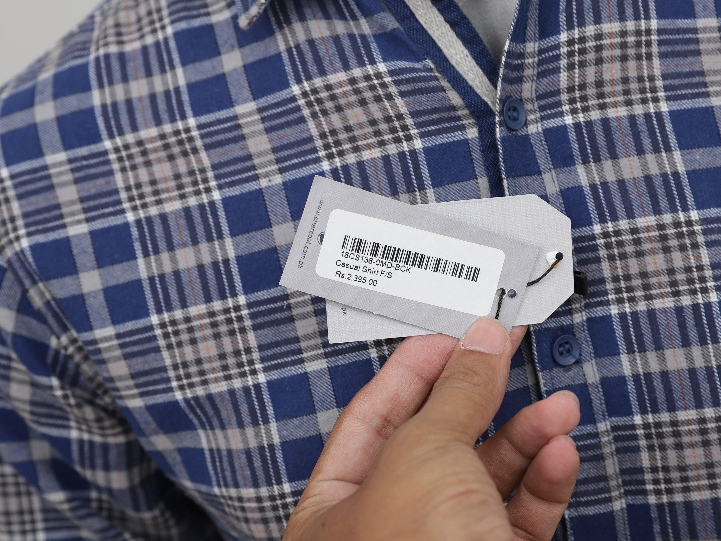 Blue-and-white plaid shirt with size tag attached near the button placket