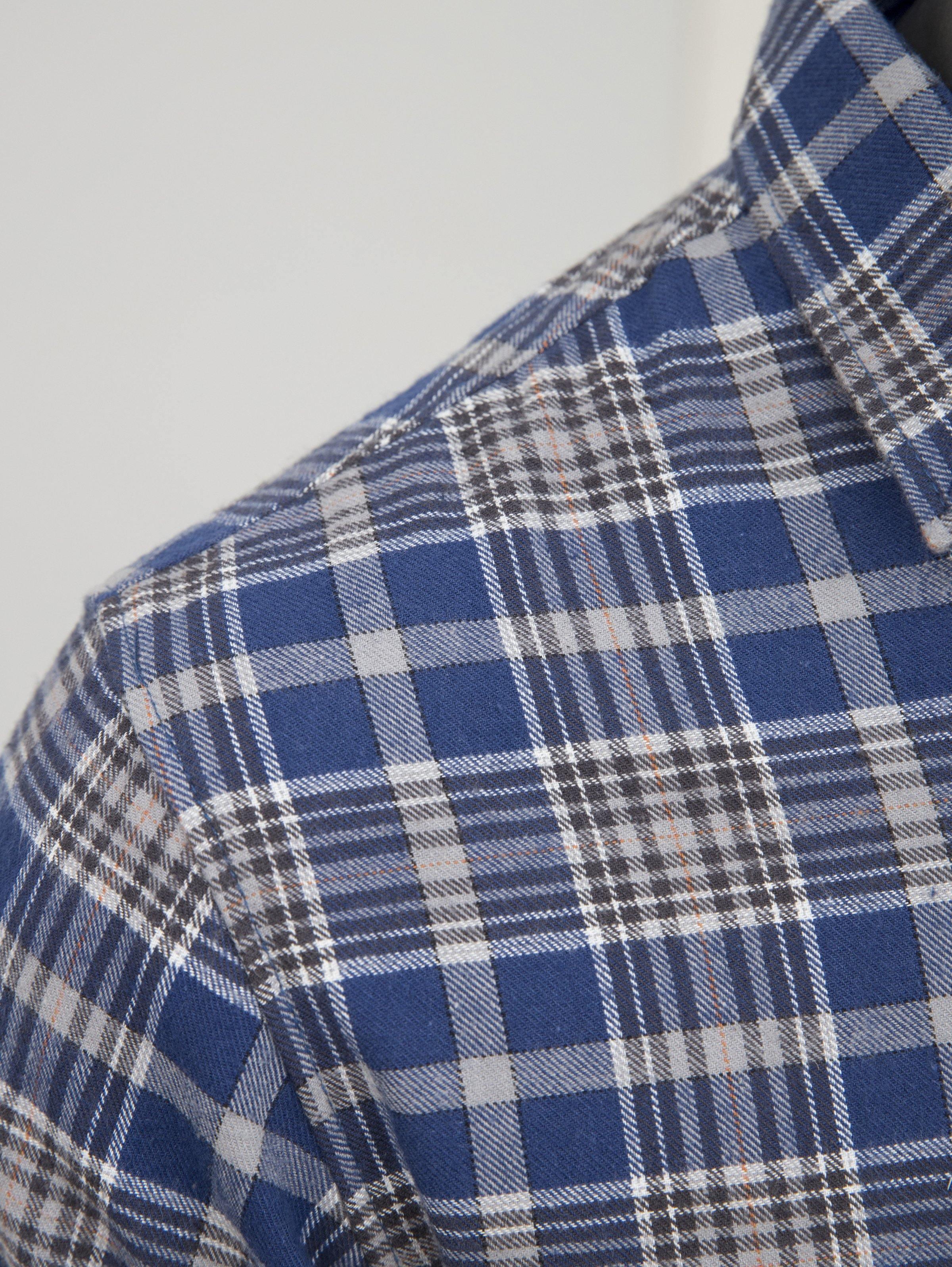 Close-up of blue-and-white plaid fabric on the shirt shoulder