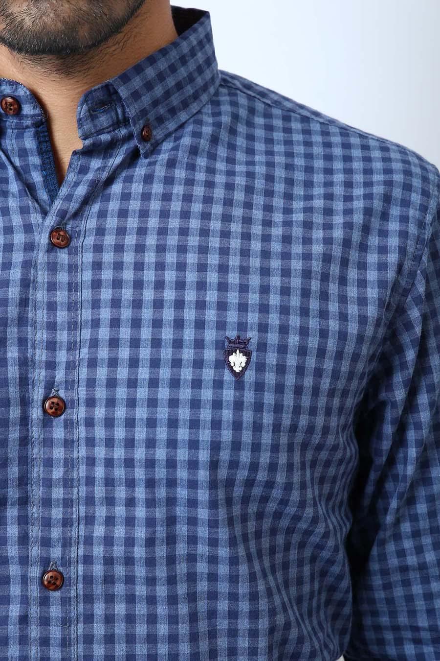 Men's blue checkered shirt close-up, chest emblem and brown button details