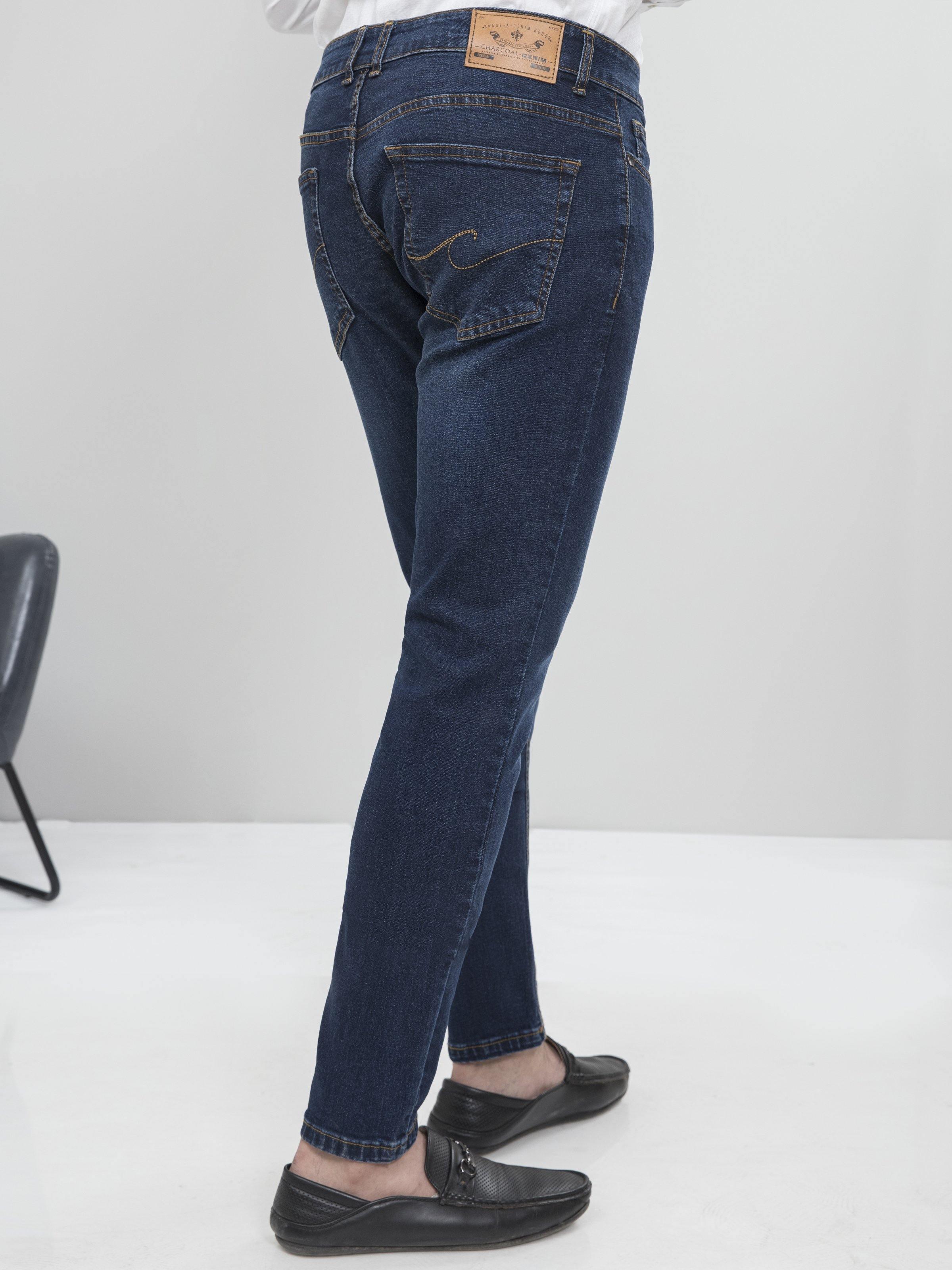 Dark blue slim-fit jeans back view with stitched pockets and waistband label