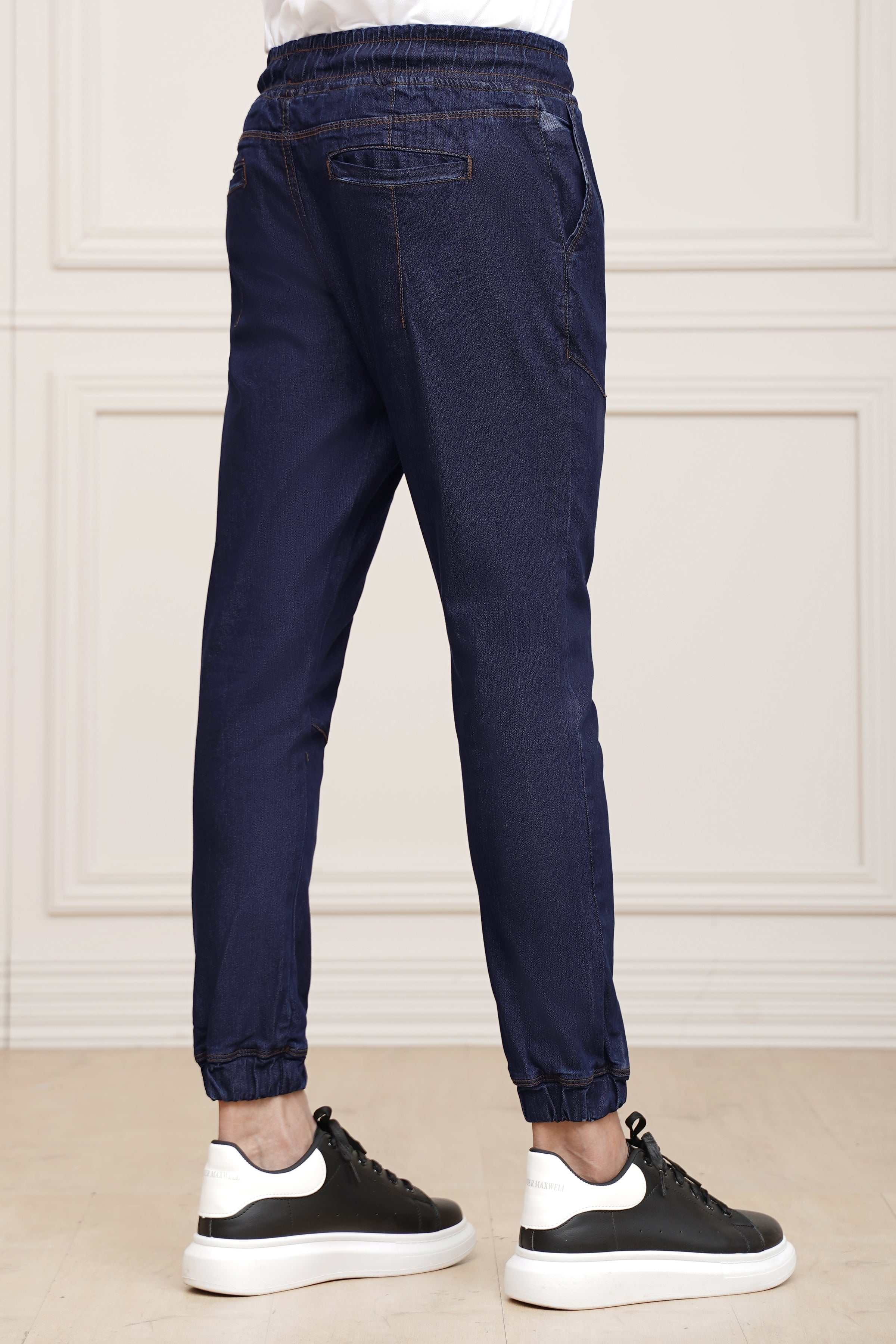 Mid blue denim trousers rear view with elastic waist, back pocket and cuffed hem