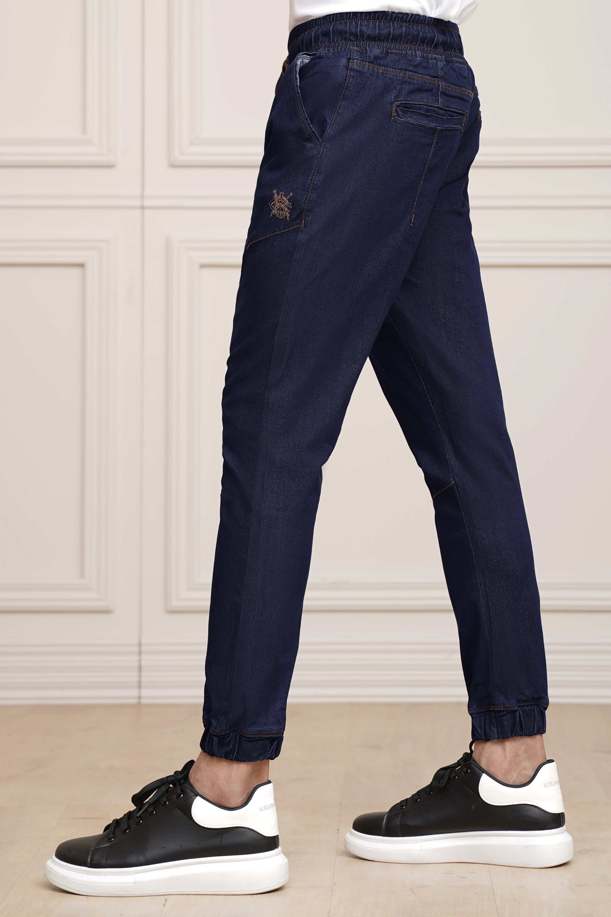Mid blue denim trousers with elastic waist, cuffed ankle and side pockets