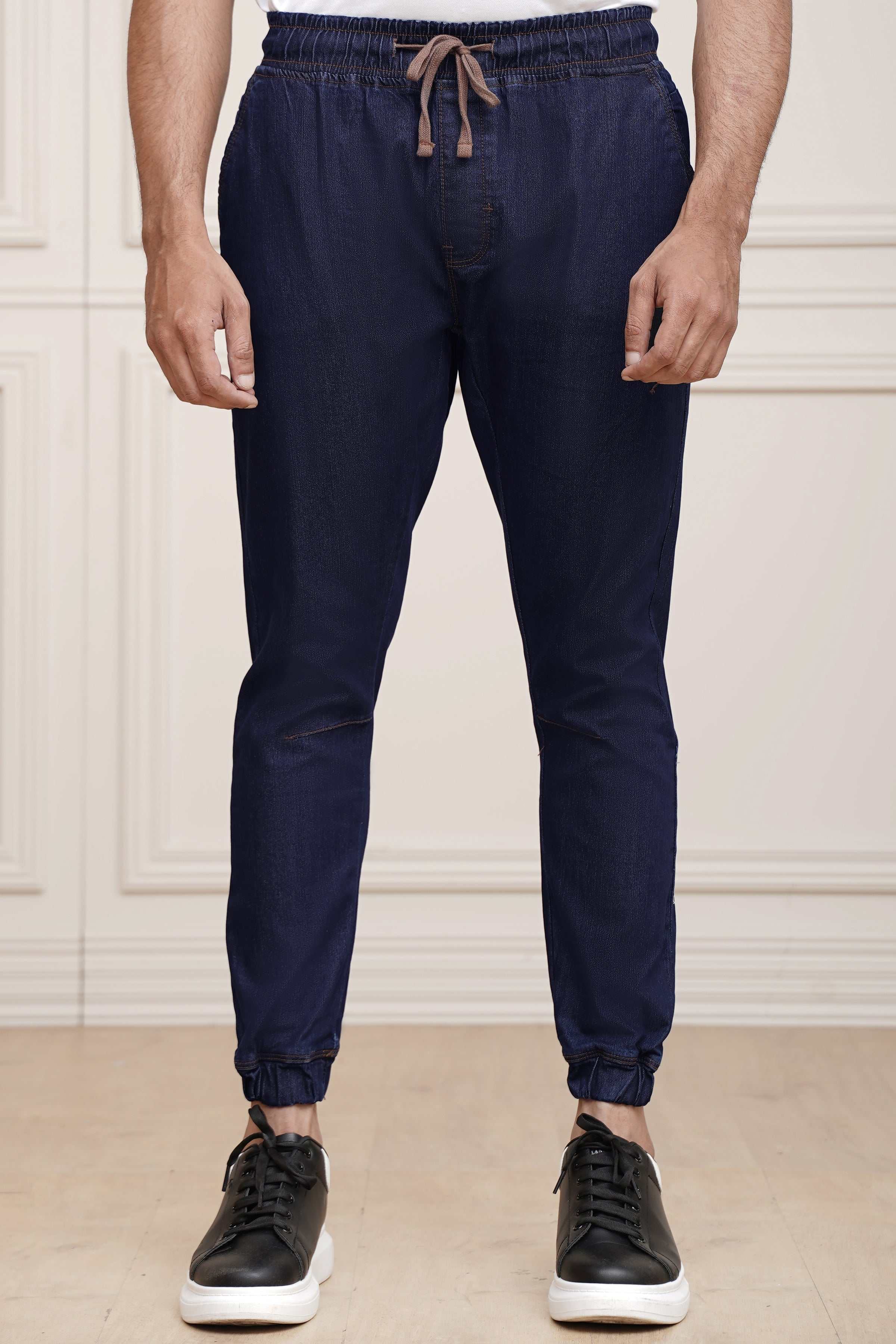 Mid blue denim jogger trousers with drawstring waist, tapered legs and cuffed hems