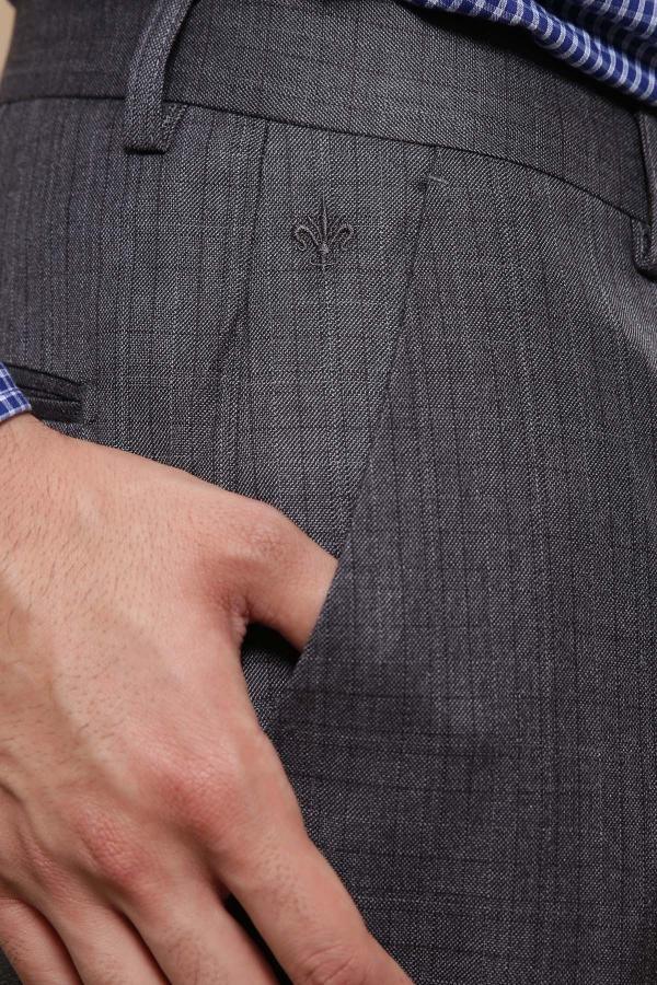 Dark grey dress pants close-up with fleur-de-lis emblem and side seam stitching