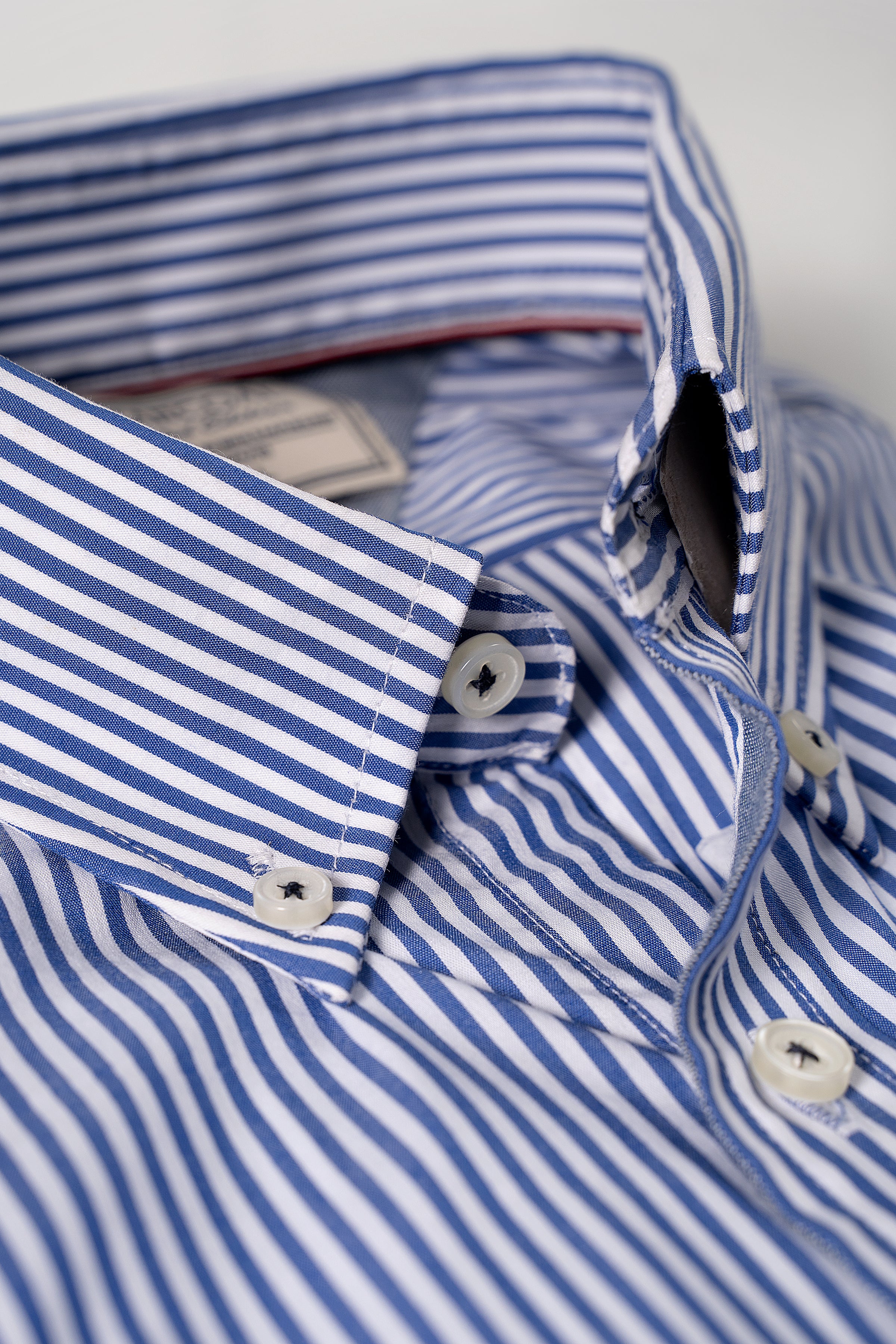 Blue and white striped shirt collar with white buttons and placket detail