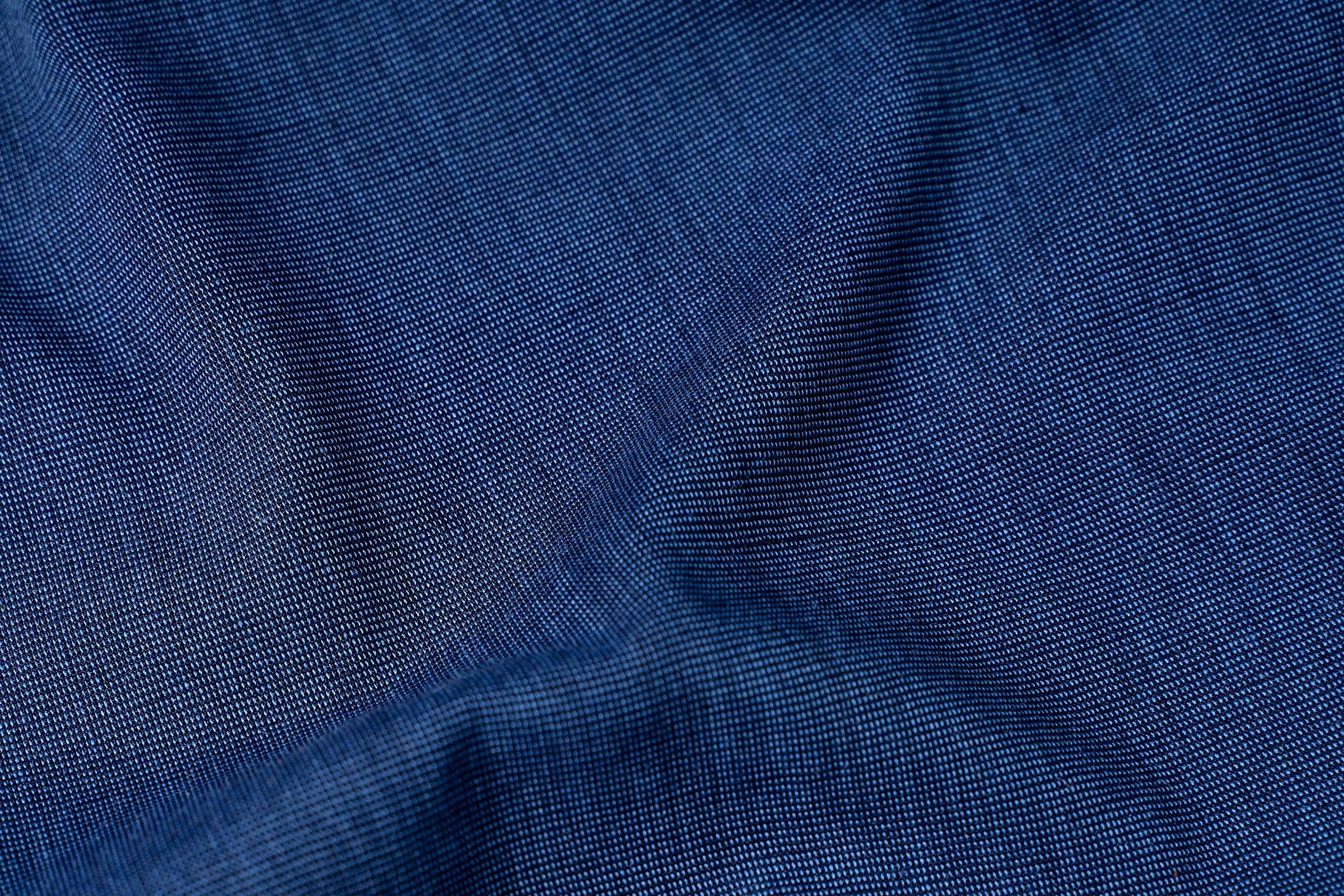 Blue self-textured fabric with fine woven pattern, close-up