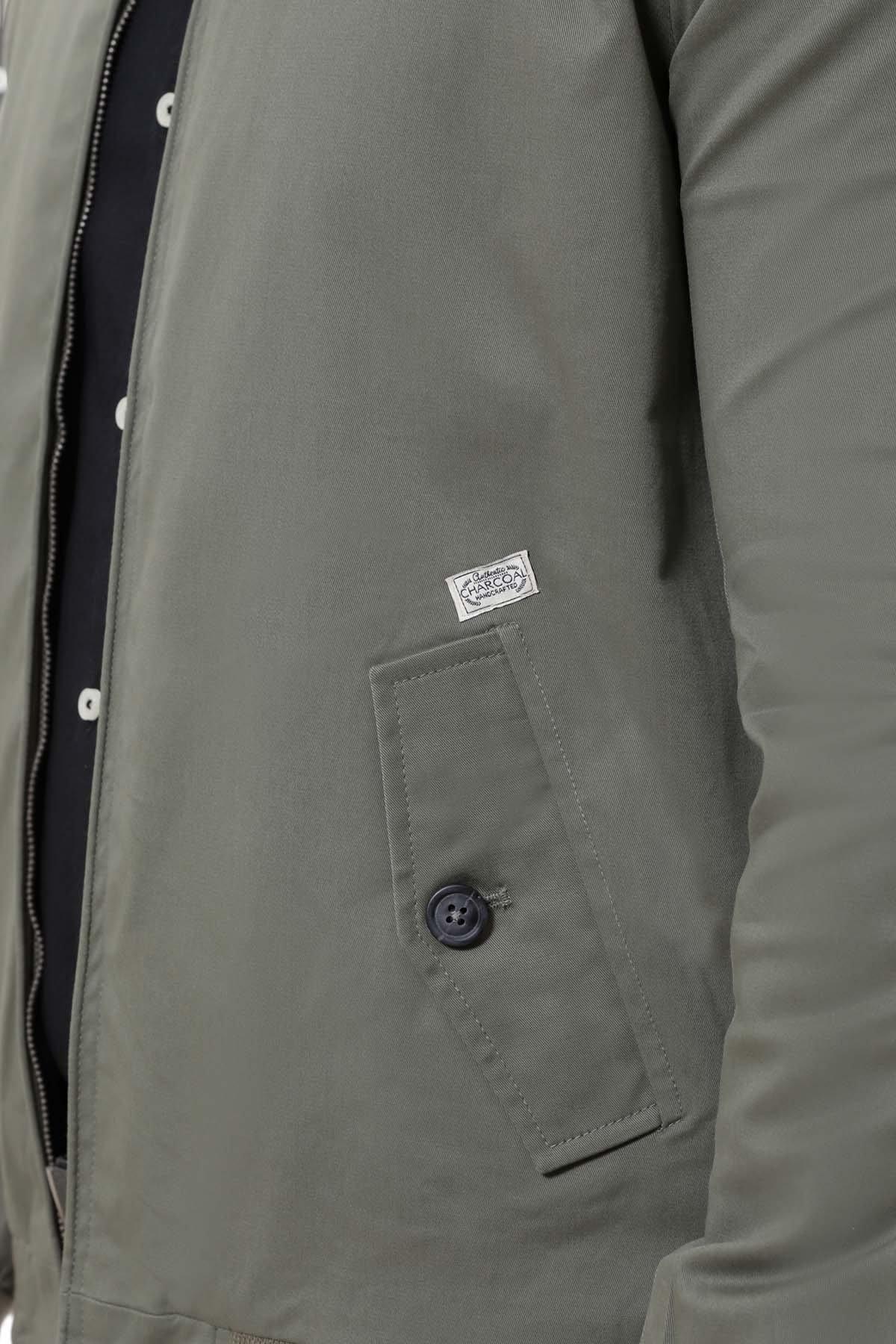 Green jacket sleeve pocket with logo patch and dark button detail