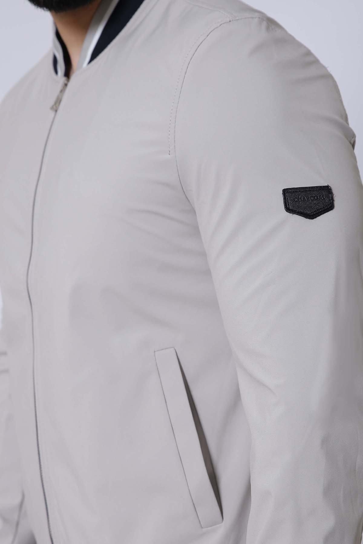 Light beige jacket sleeve with black logo patch and front pocket panel.