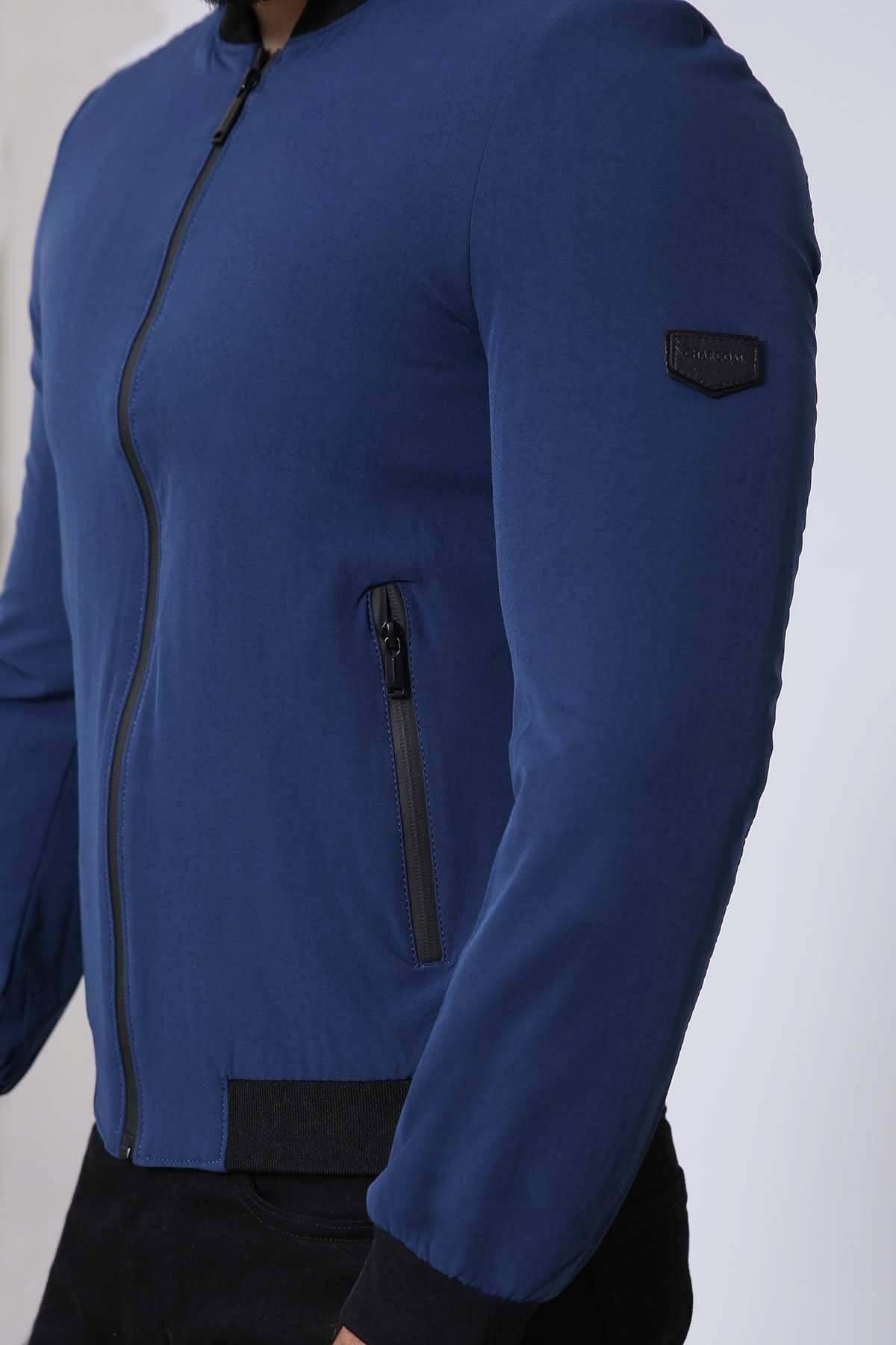 Navy full-sleeve jacket with side zipper pocket and black ribbed cuff; logo patch