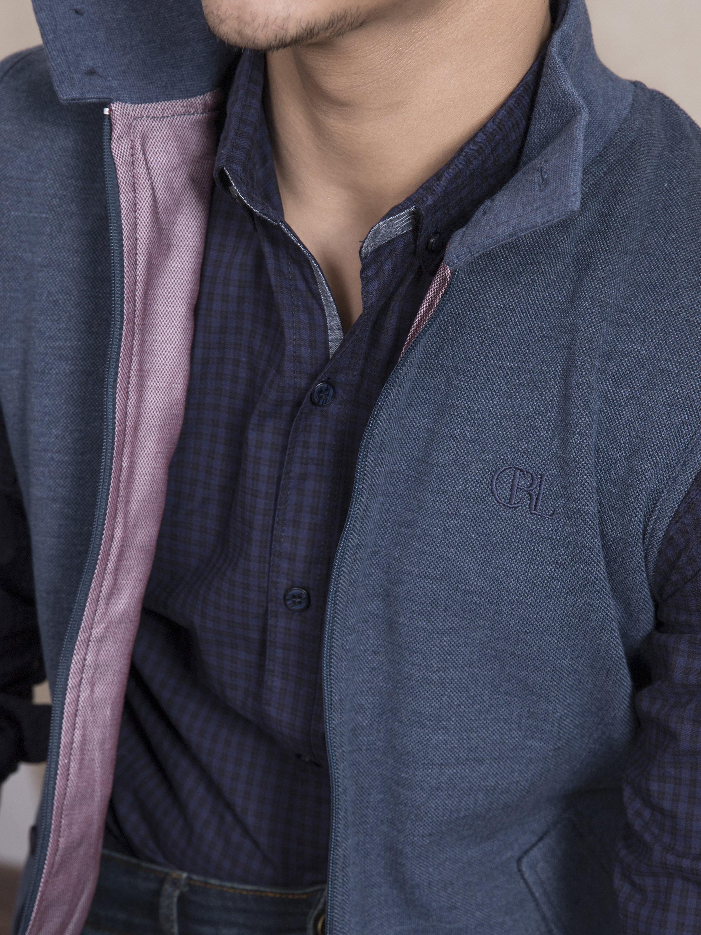 Blue sleeveless jacket close-up with zip front and small chest logo