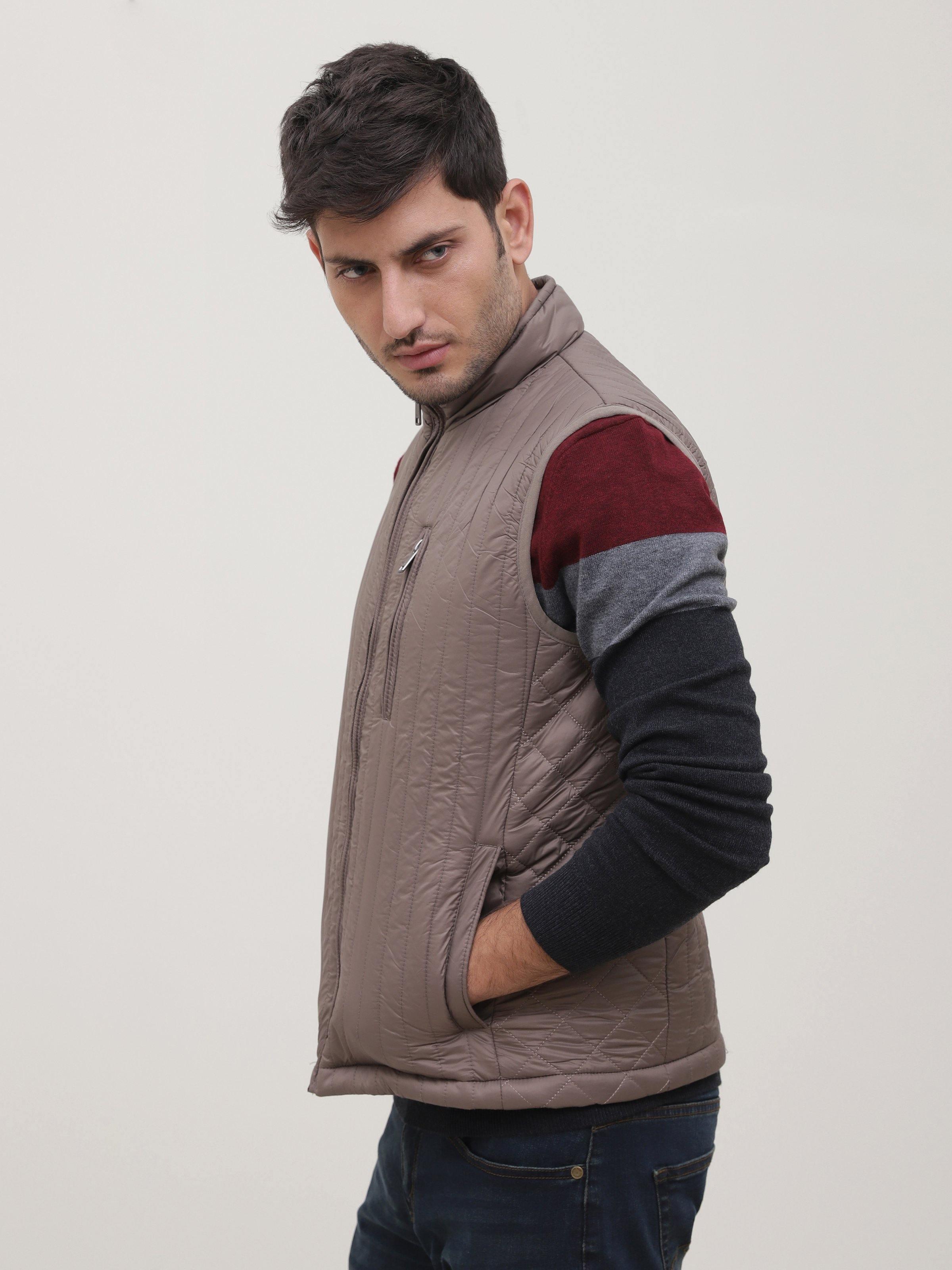 Taupe quilted sleeveless jacket with high collar and front zipper, side view