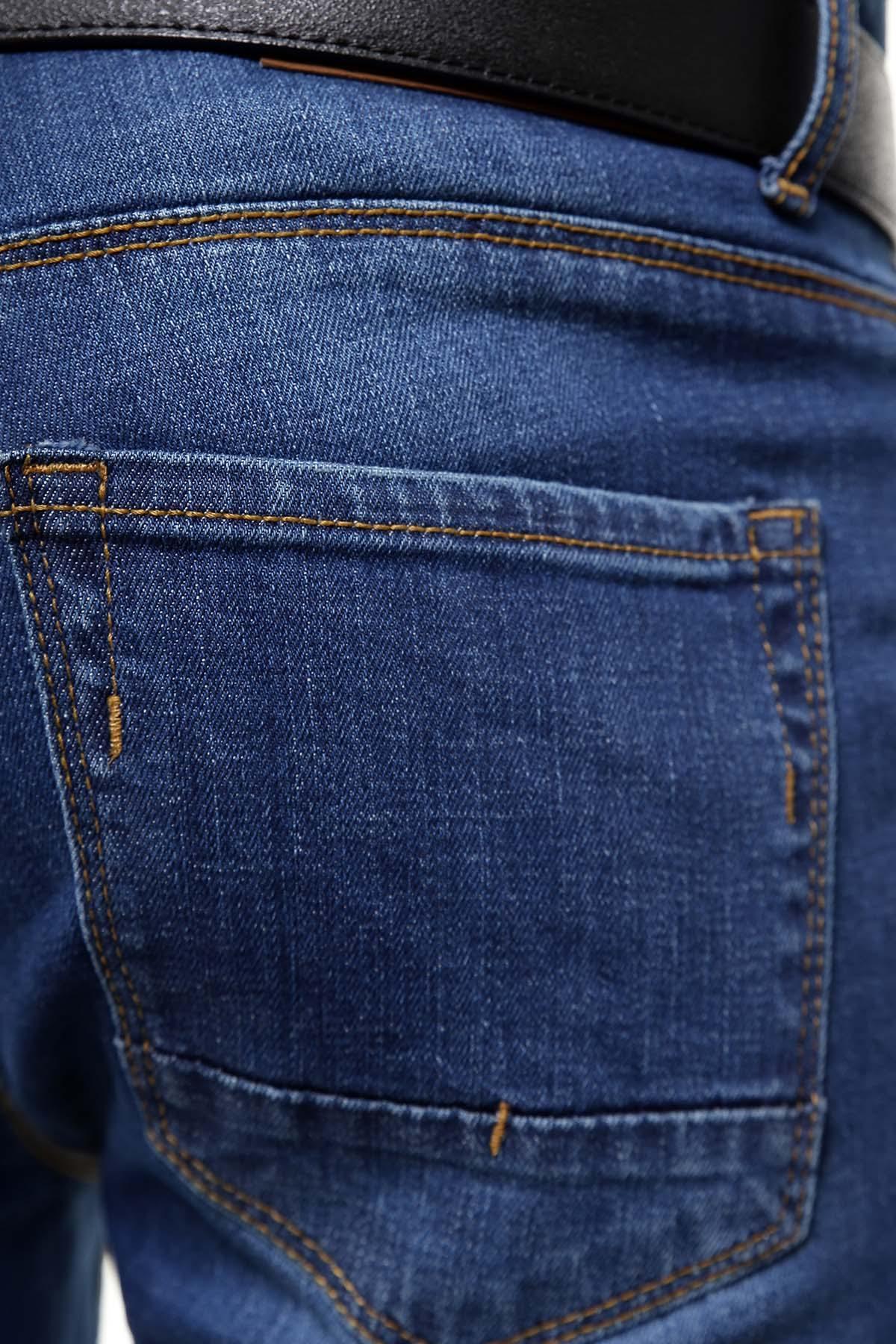 Light blue denim jeans pocket close-up with stitched seams and metal rivet