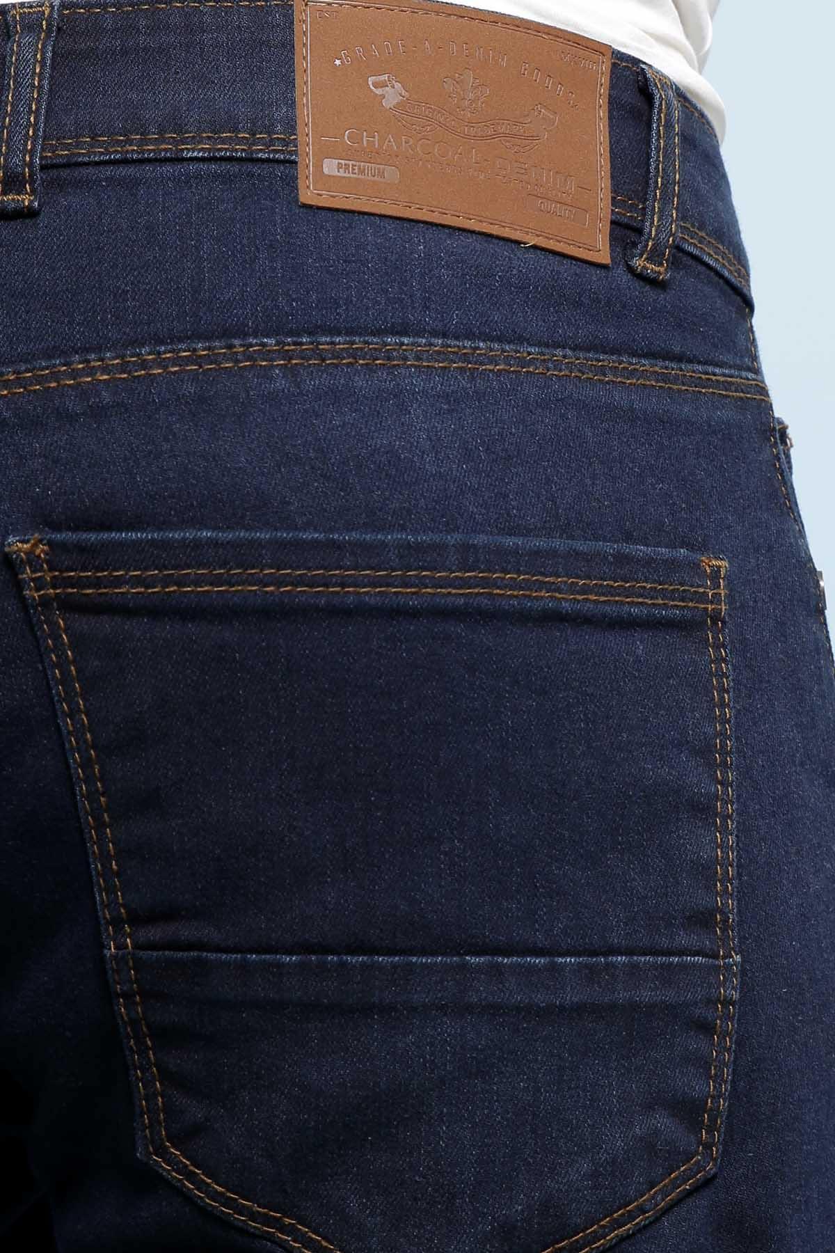 Mid navy denim jeans back pocket close-up with leather logo patch