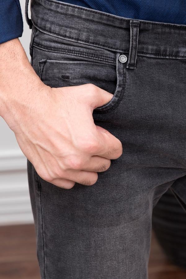 Dark grey slim-fit jeans with button fly and stitched front pocket, close-up