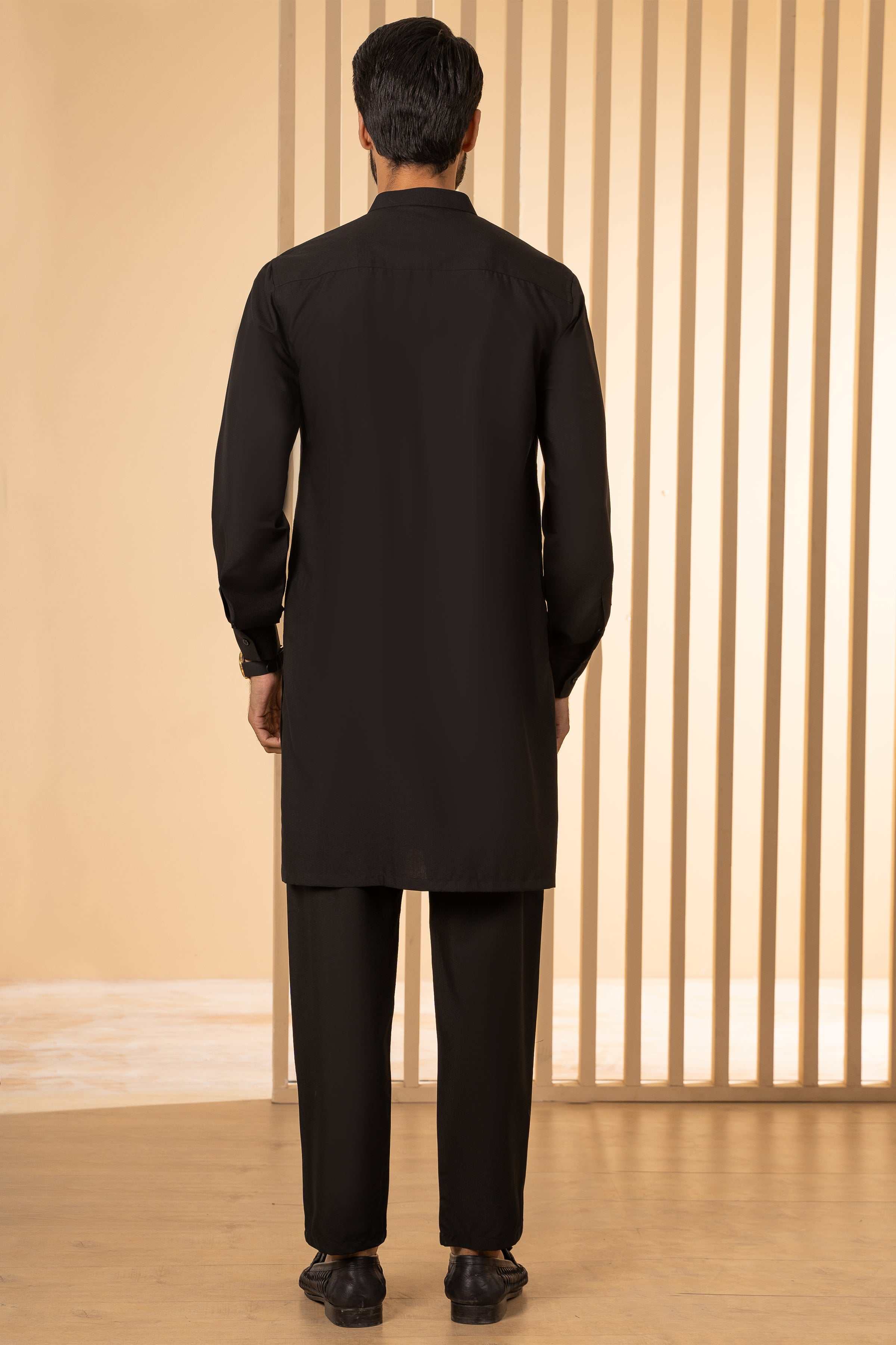 Back view of men's black kurta and pajama set with full-length trousers